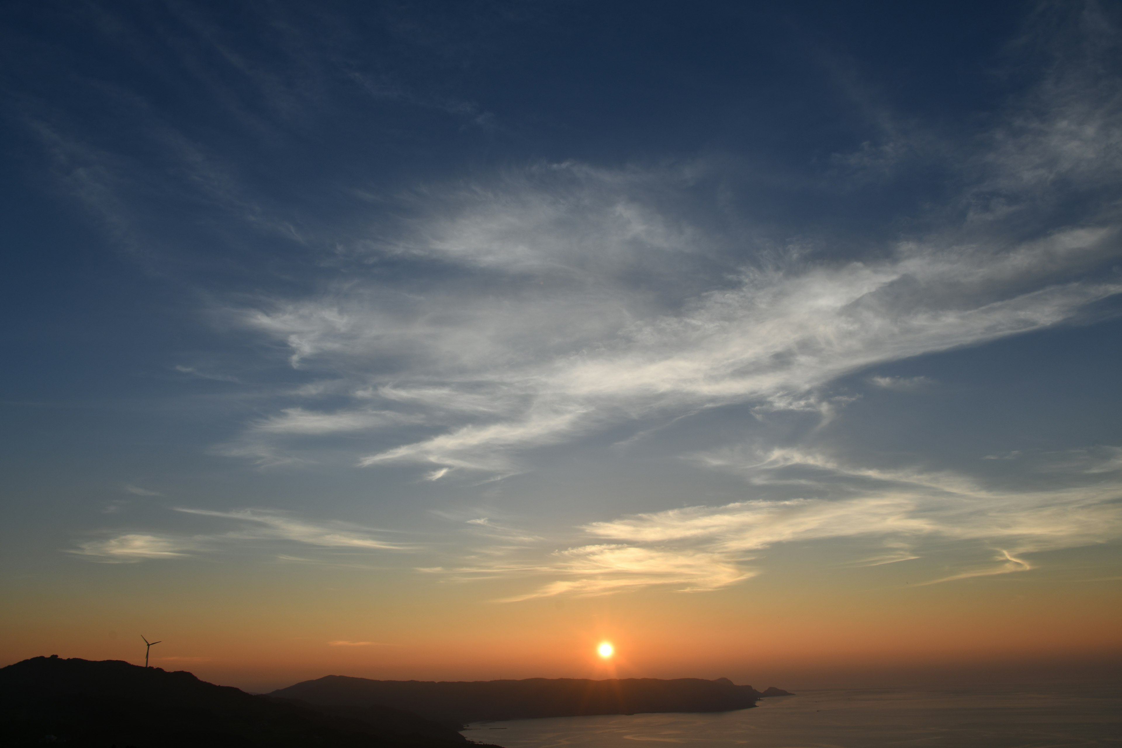 Senja yang menakjubkan di atas laut dengan awan berwarna