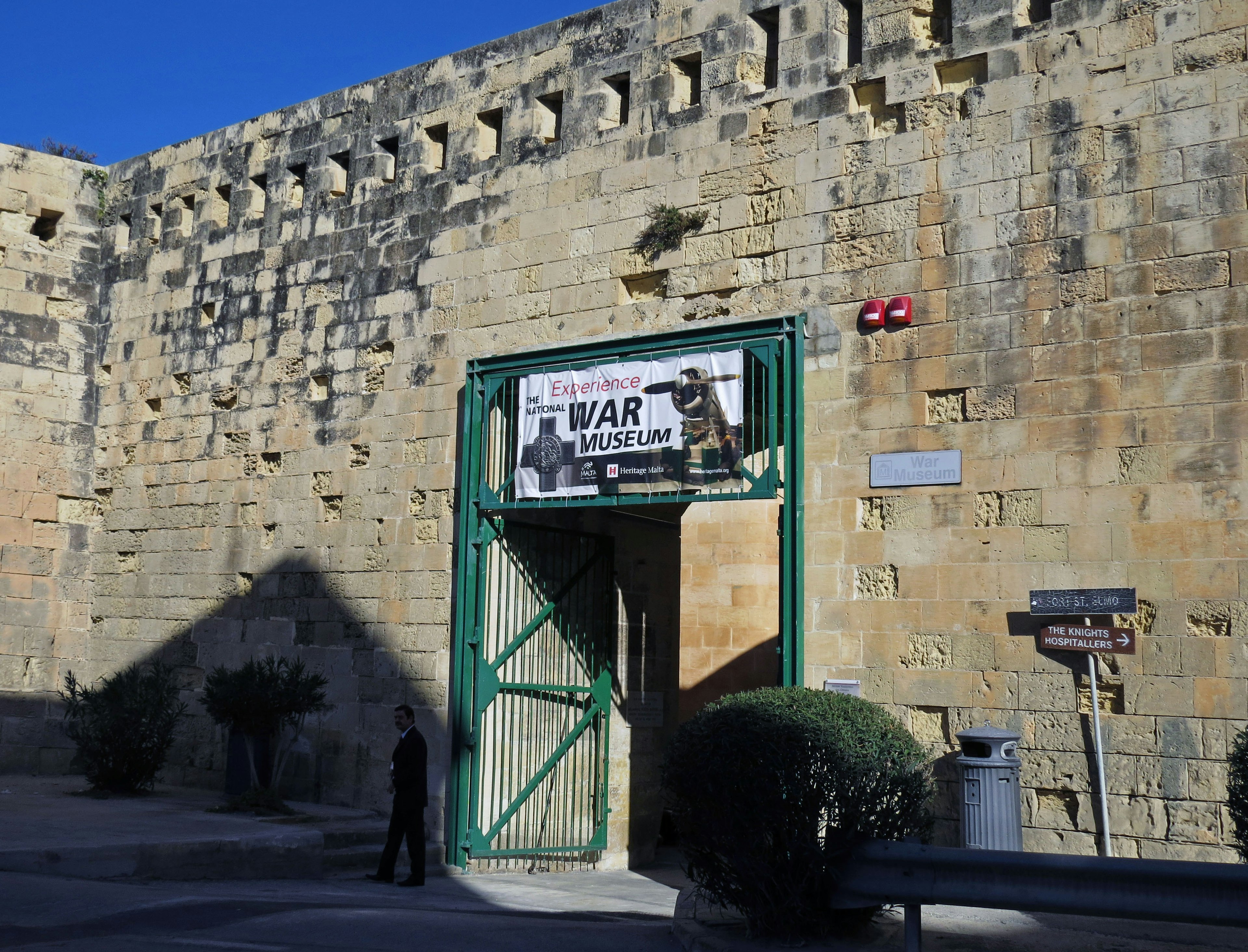 Historic stone wall with a green gate featuring a sign for Bivar