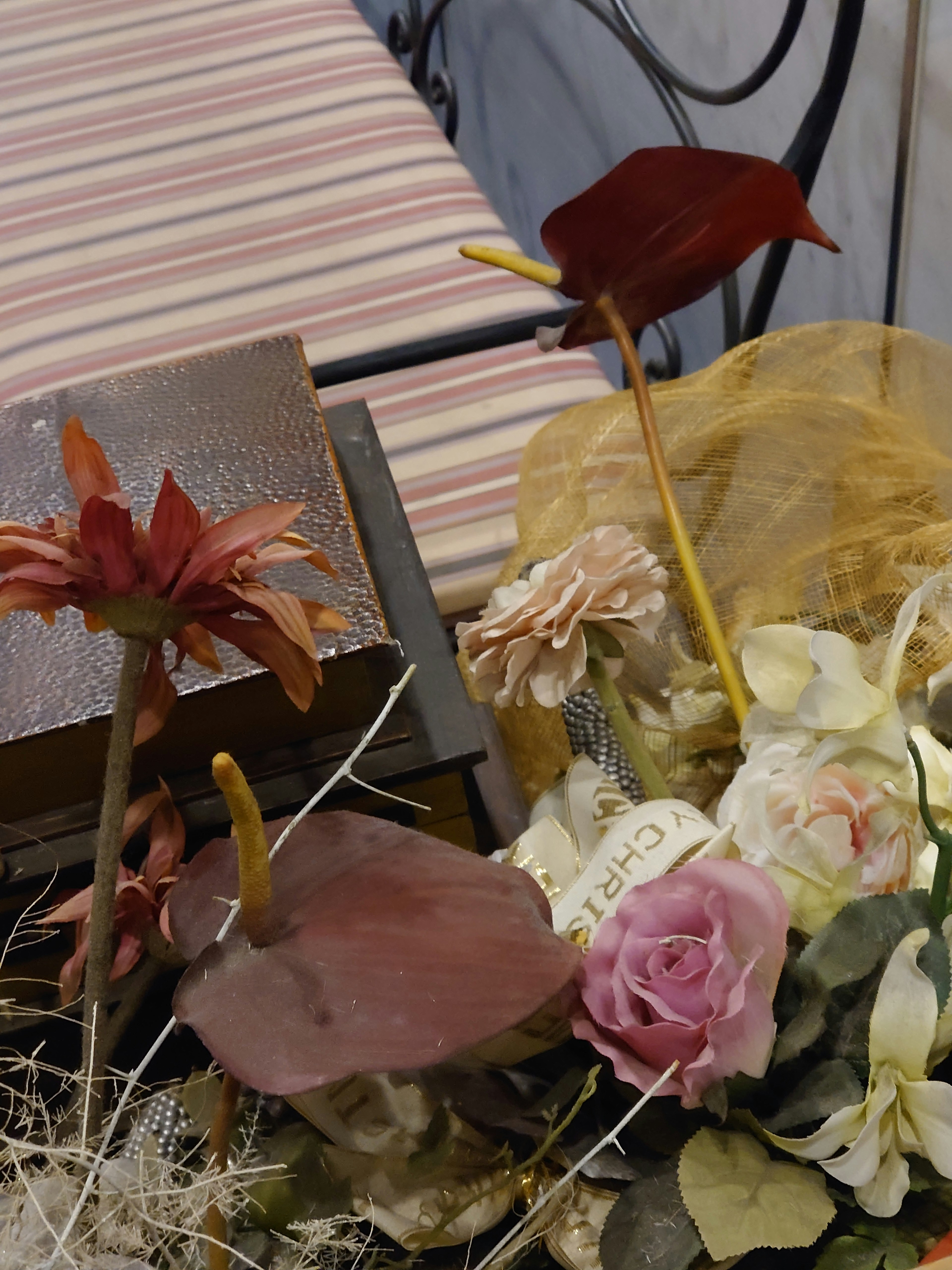 Floral arrangement featuring red flowers and a pink rose