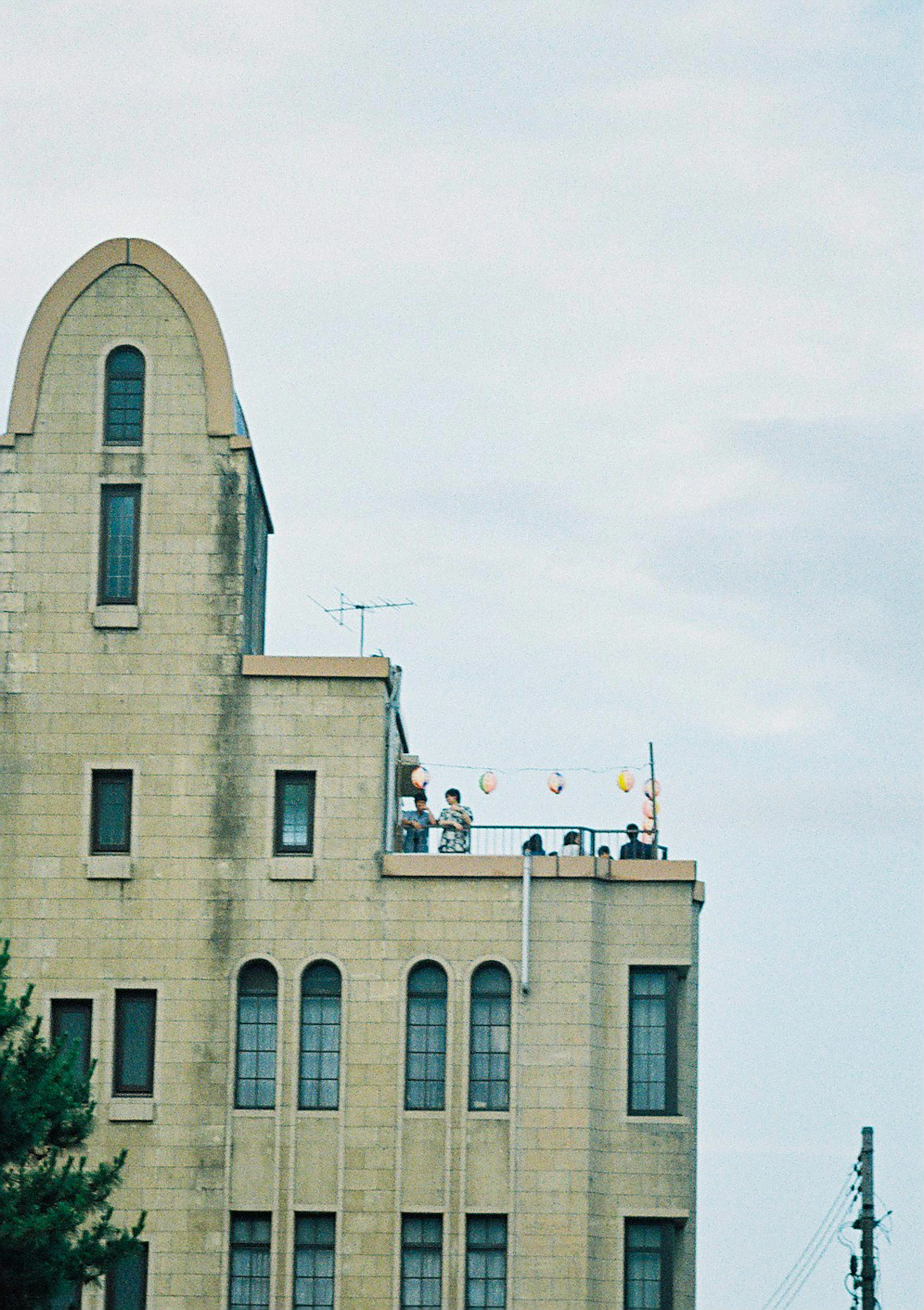 People on the rooftop of a building under a blue sky