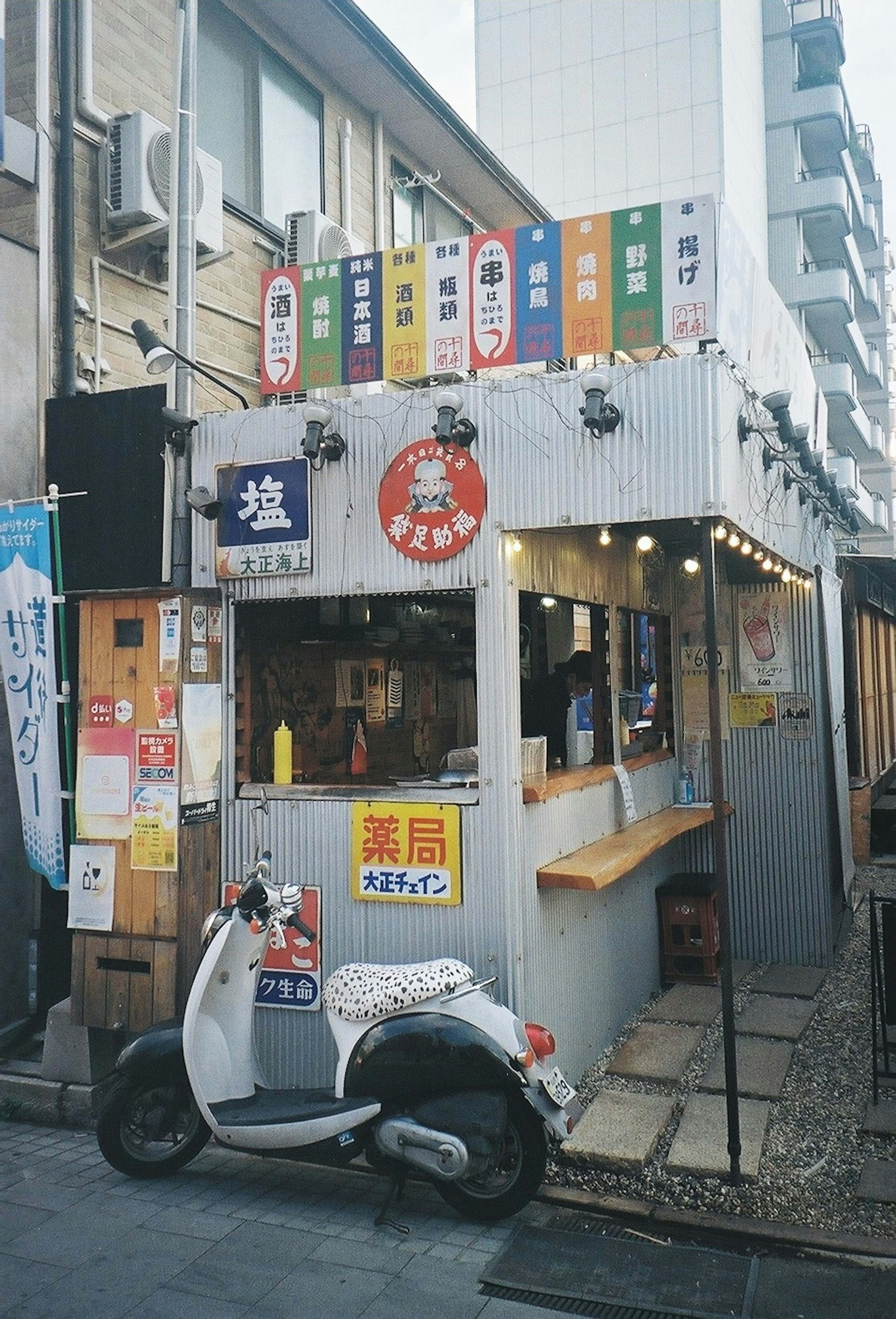 Extérieur d'un petit stand de nourriture avec un scooter blanc garé devant