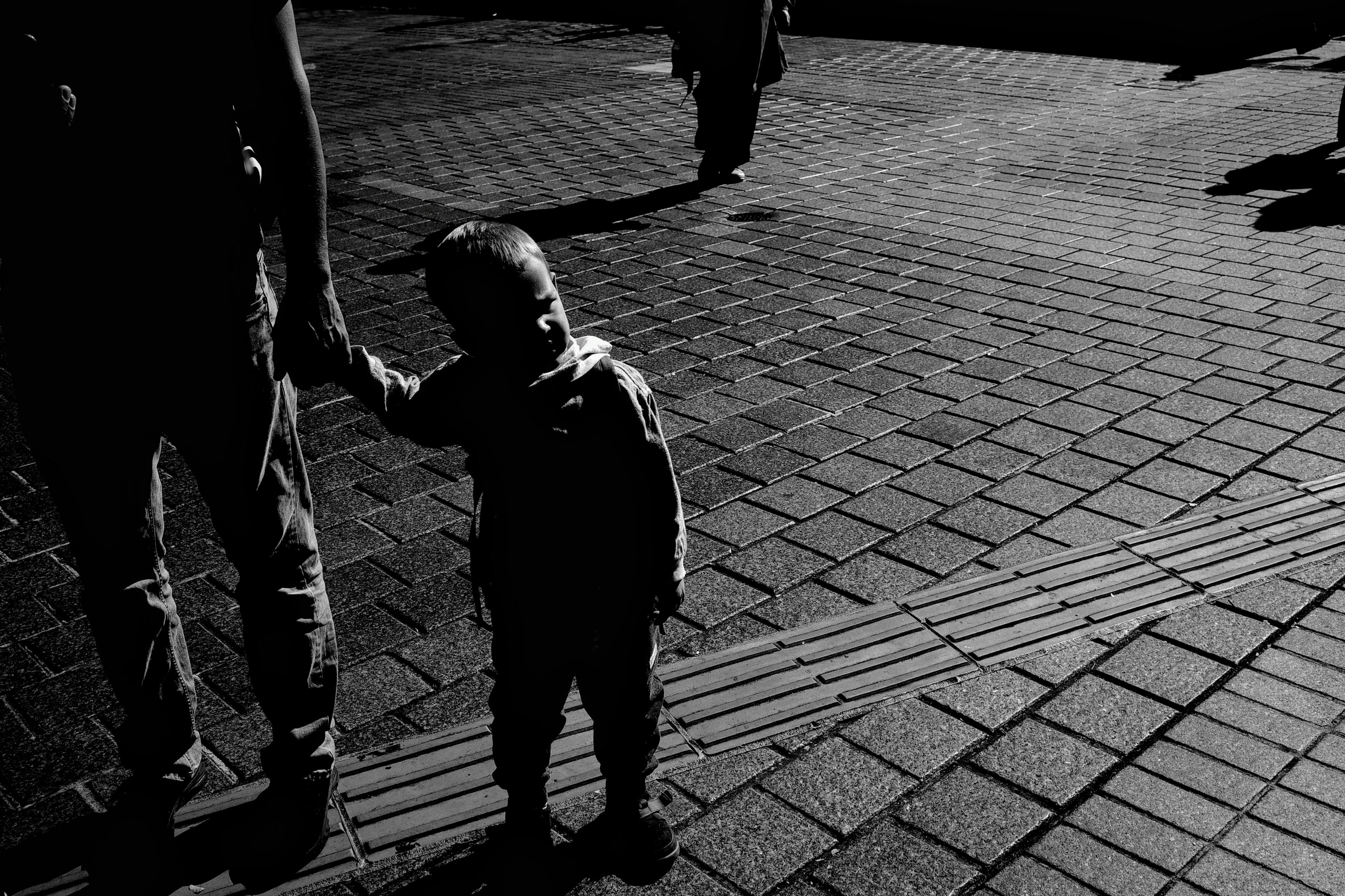 Bambino che tiene la mano di un adulto in una foto in bianco e nero