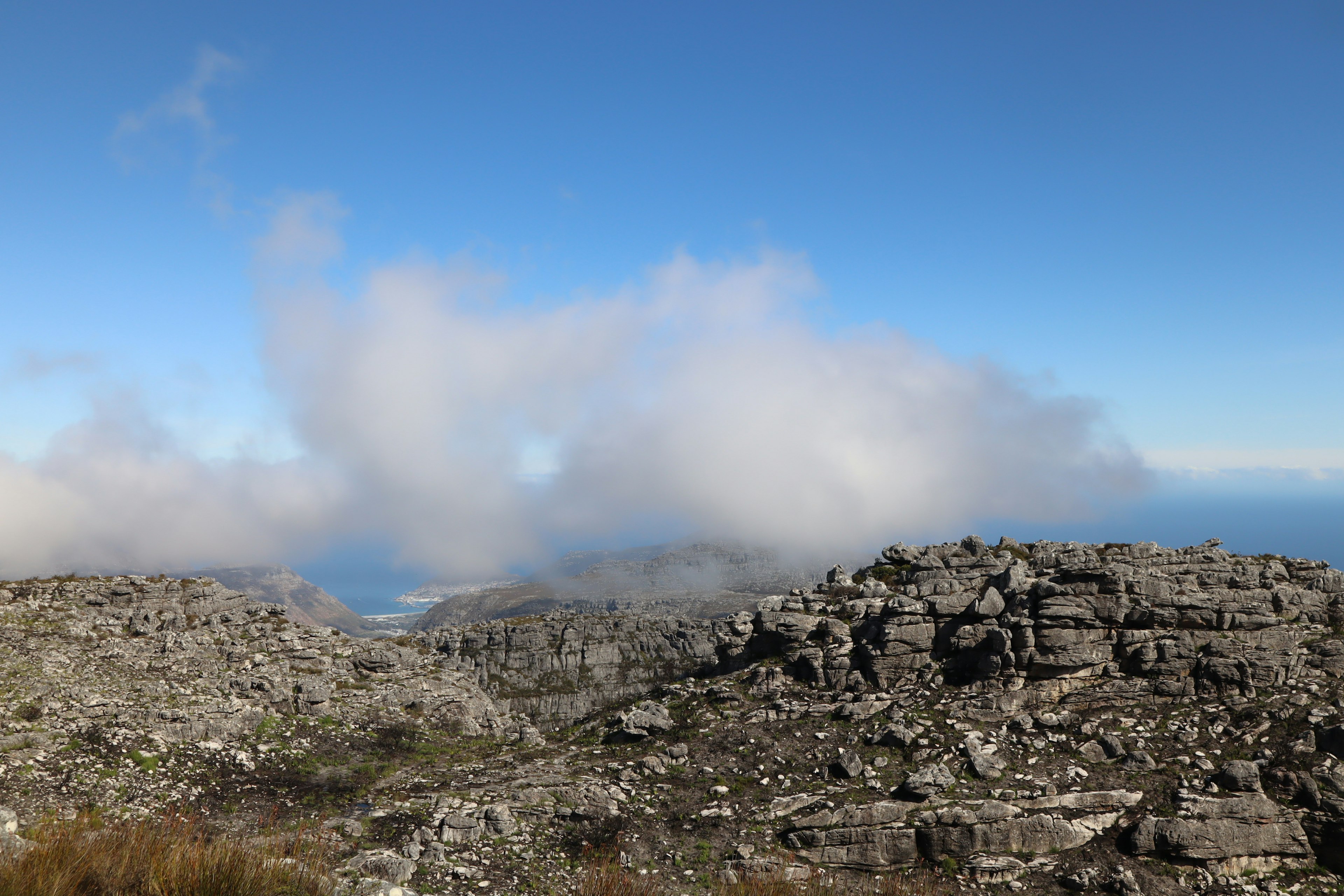 Felsige Landschaft mit Wolken und Meerblick