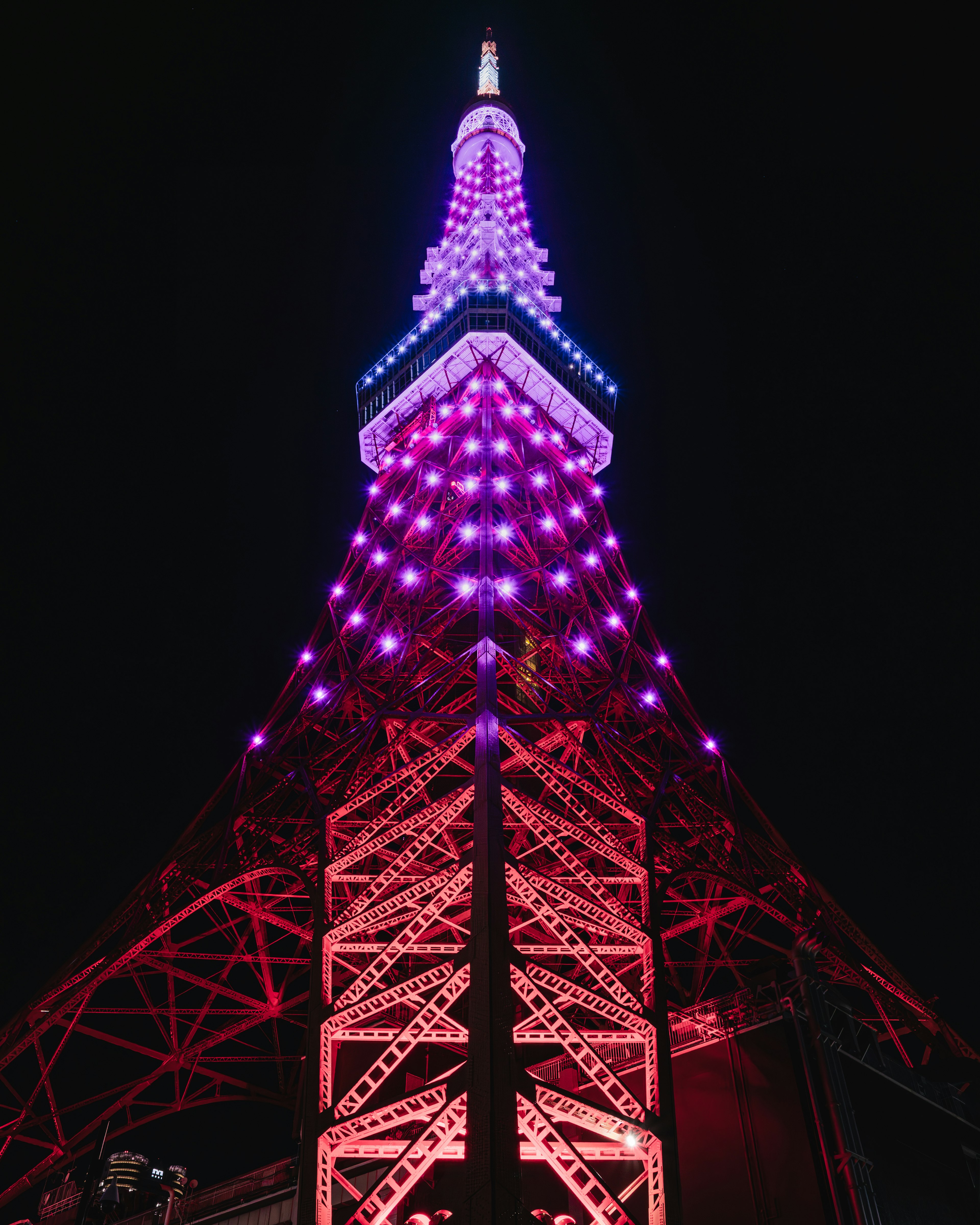 Torre de Tokio de noche, iluminada con luces moradas, estructura impresionante