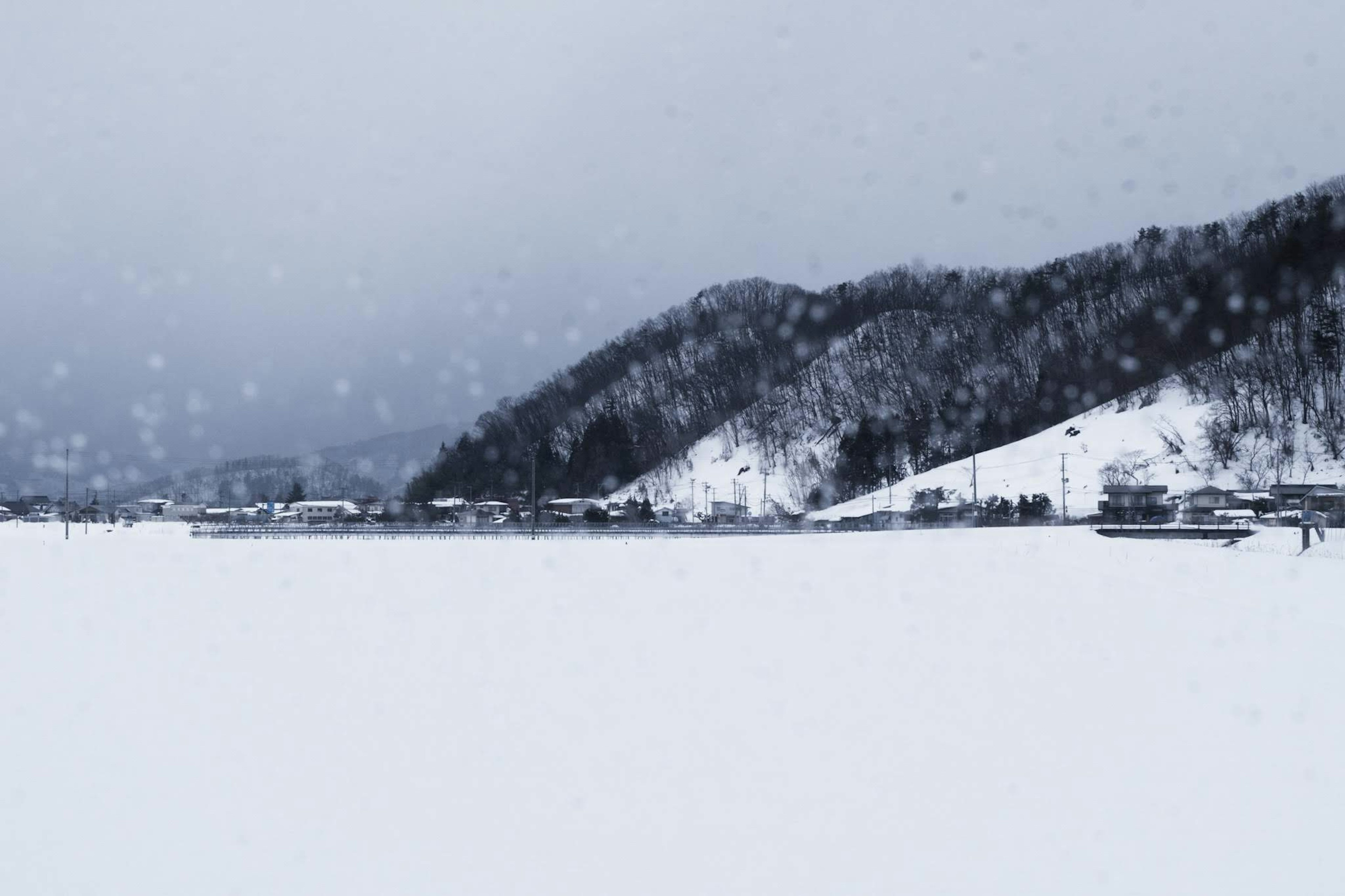 Paesaggio innevato con montagne scure e cielo nuvoloso