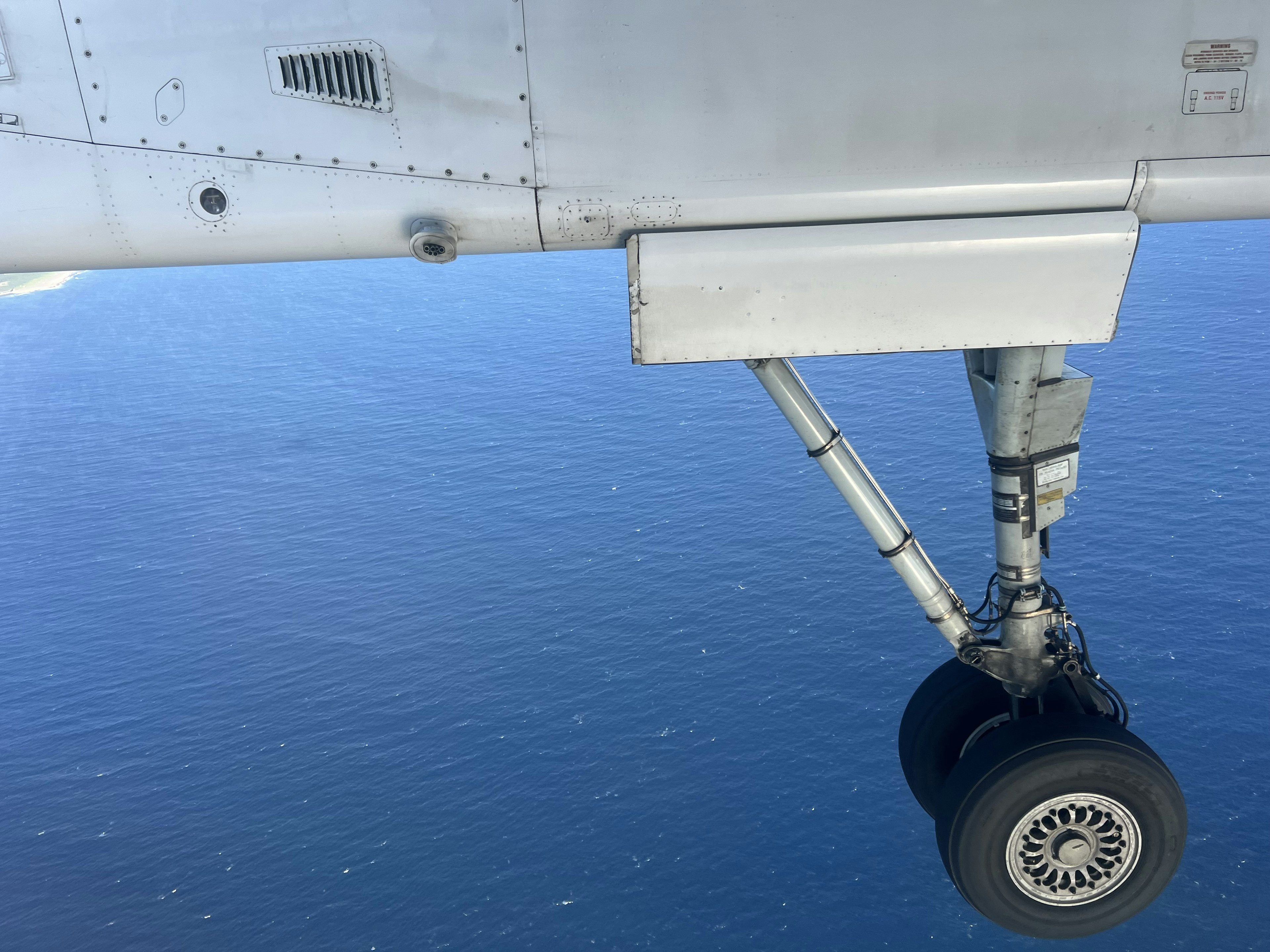 Gros plan sur un train d'atterrissage d'avion au-dessus de l'océan