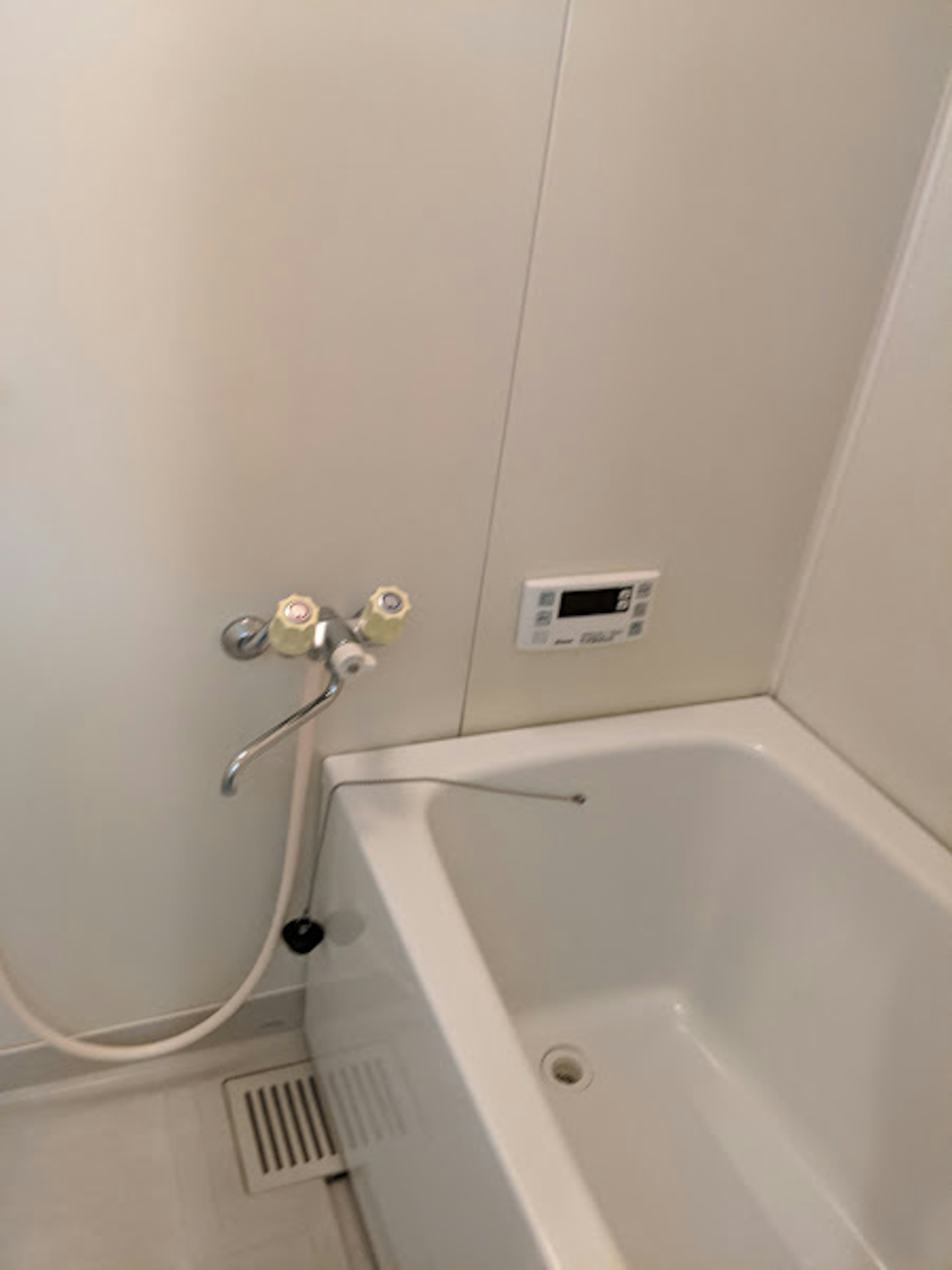 A portion of a bathroom featuring a white bathtub and shower fixtures