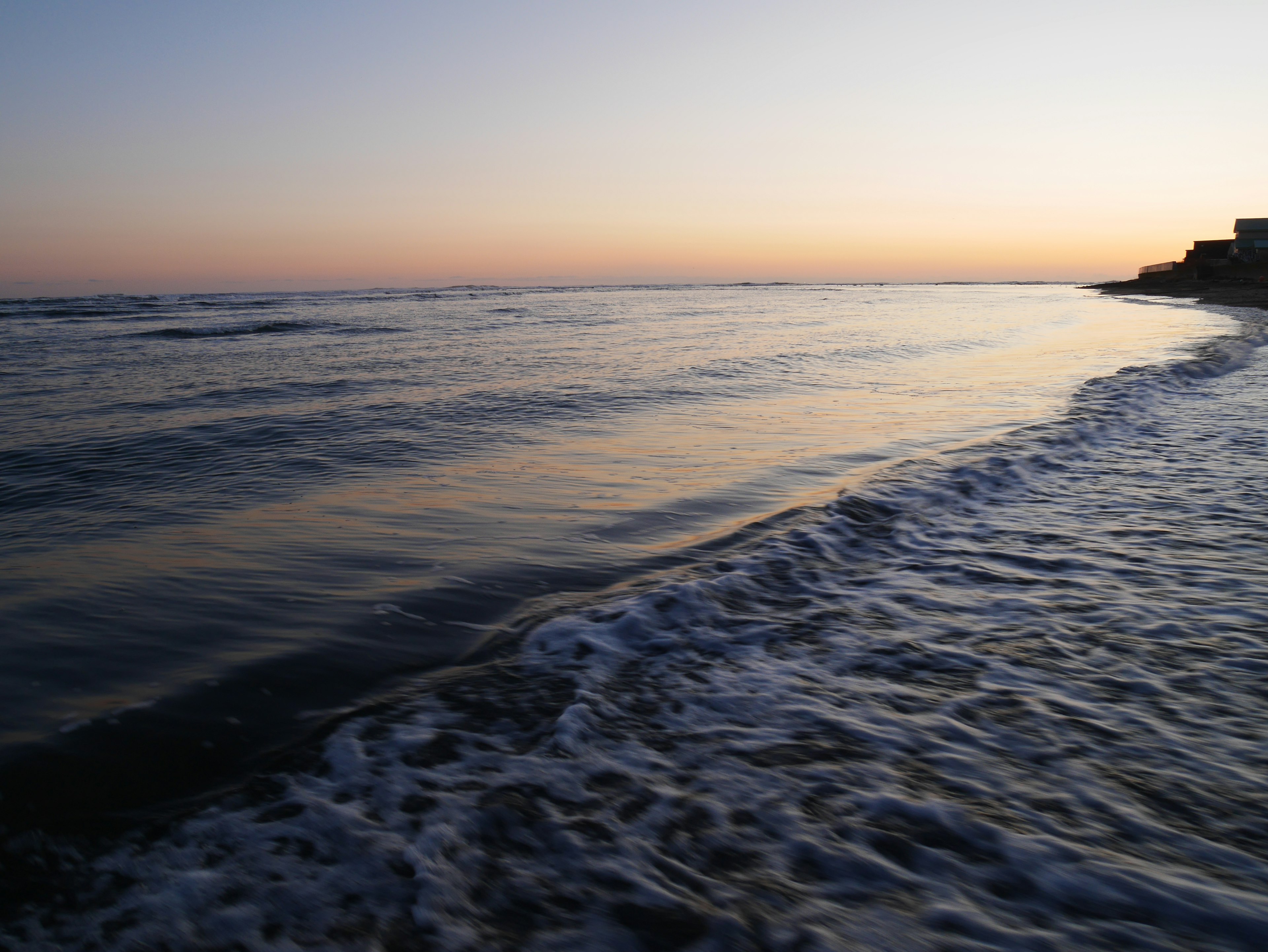 海岸線と静かな波のある夕暮れの海