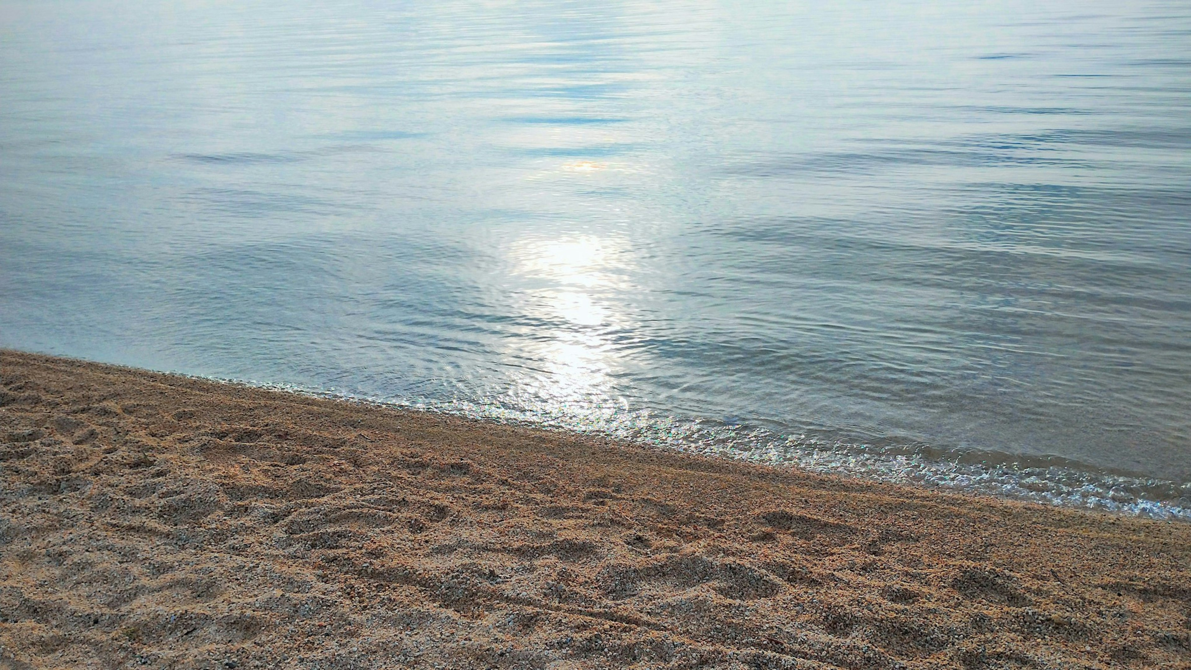 Pemandangan laut tenang dengan pantai berpasir