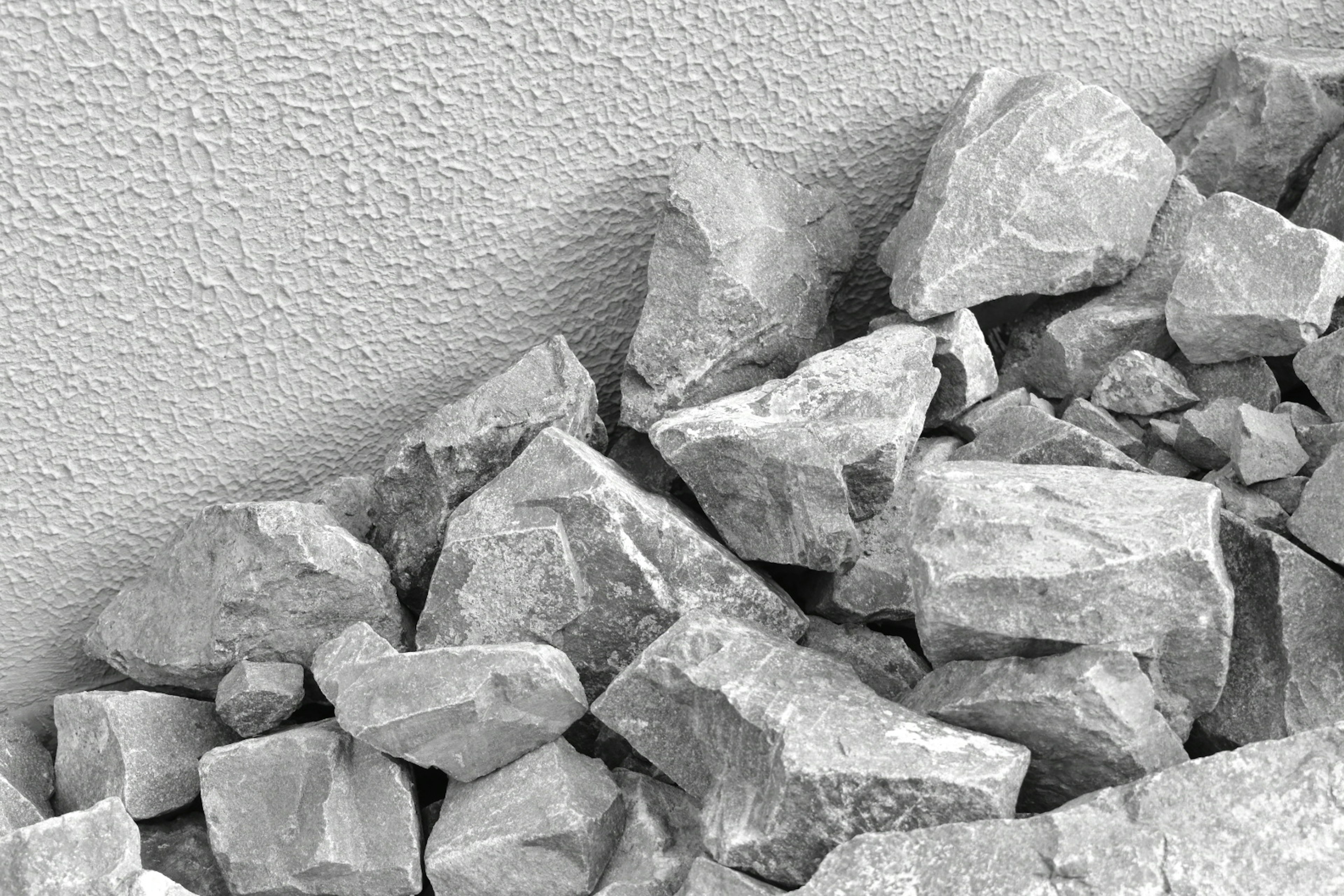 Image of gray rocks piled near a textured wall