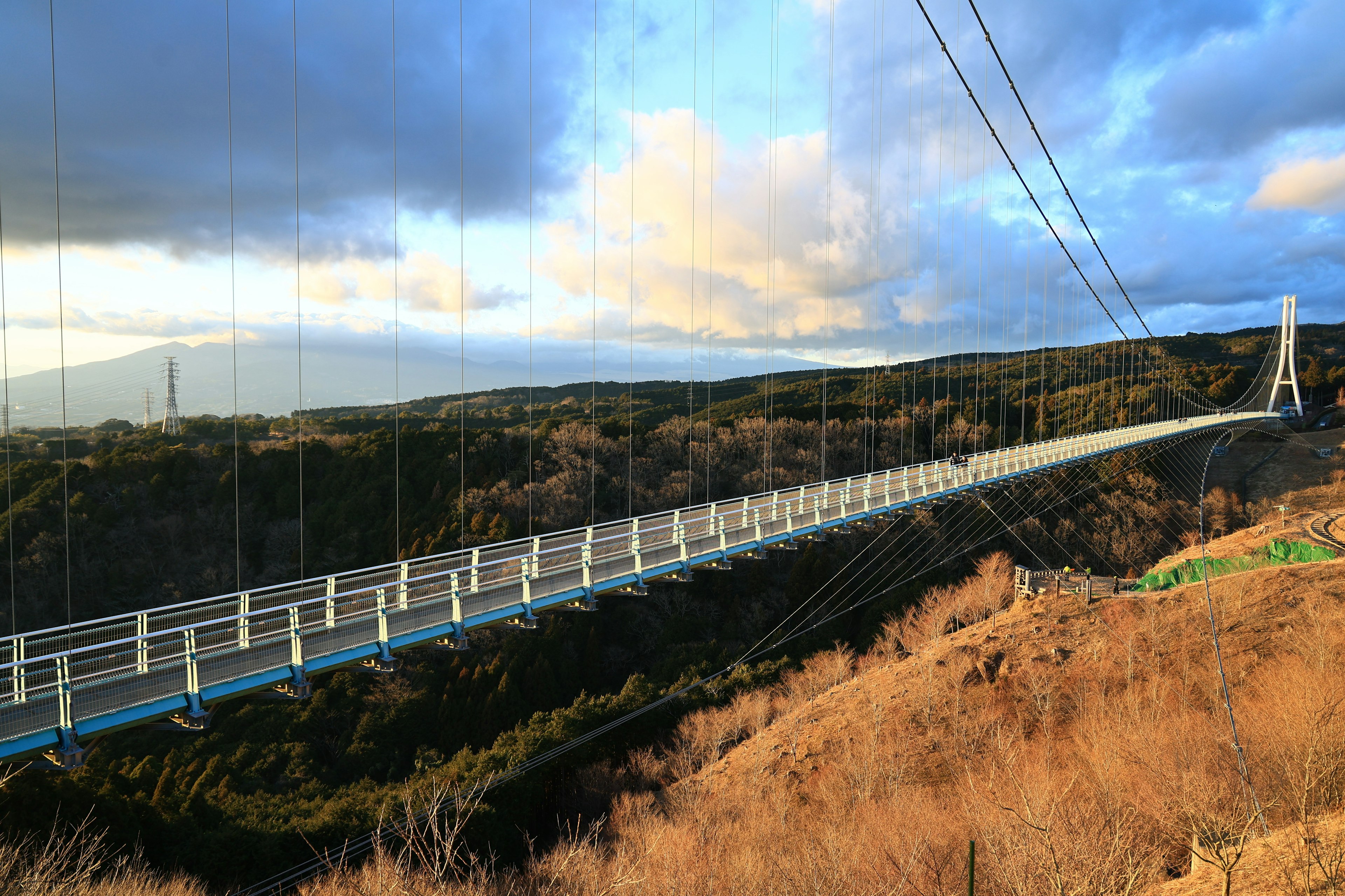 Pont suspendu avec un arrière-plan pittoresque de collines et de nuages