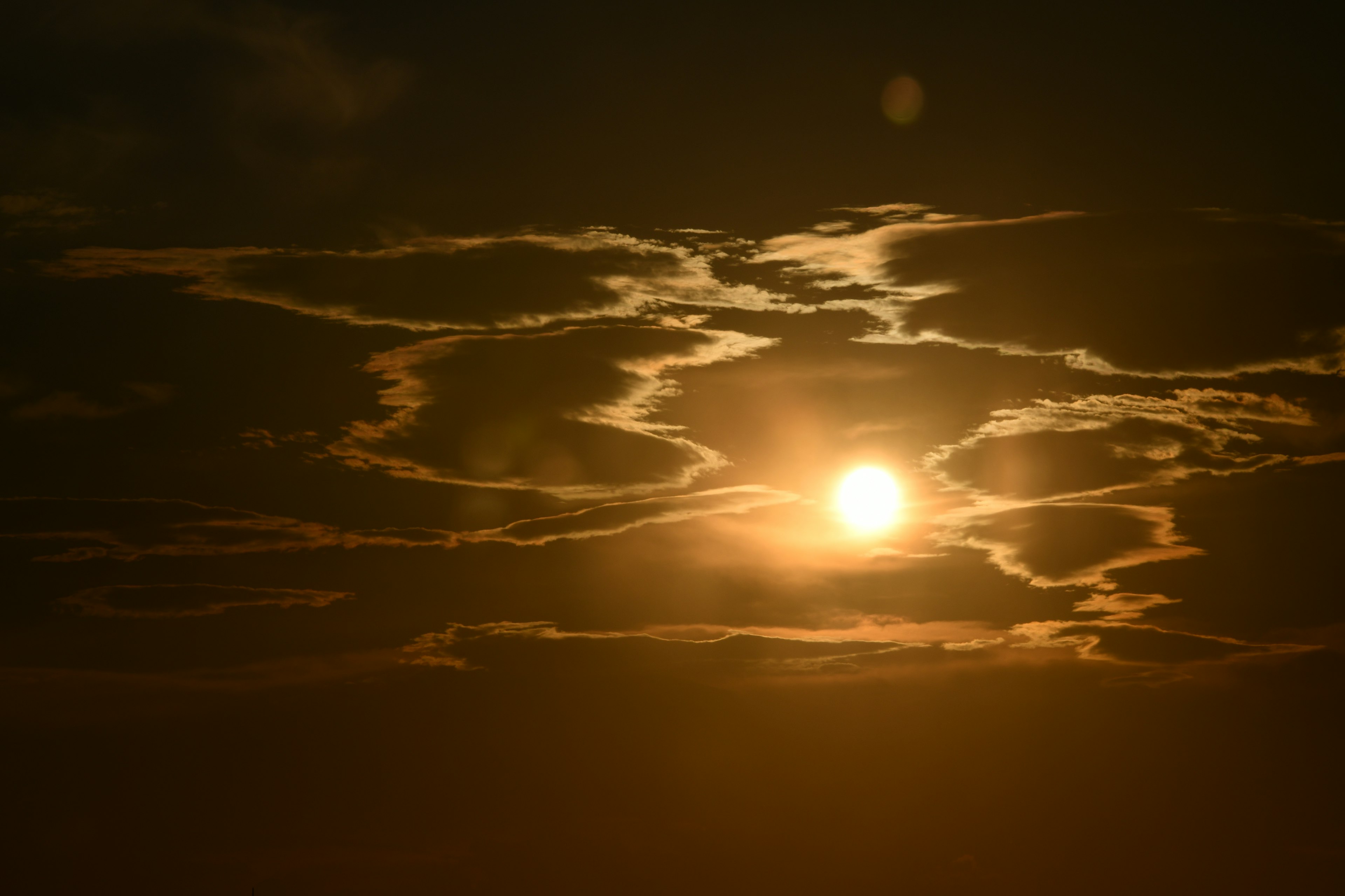 A beautiful sky with the sun visible through clouds