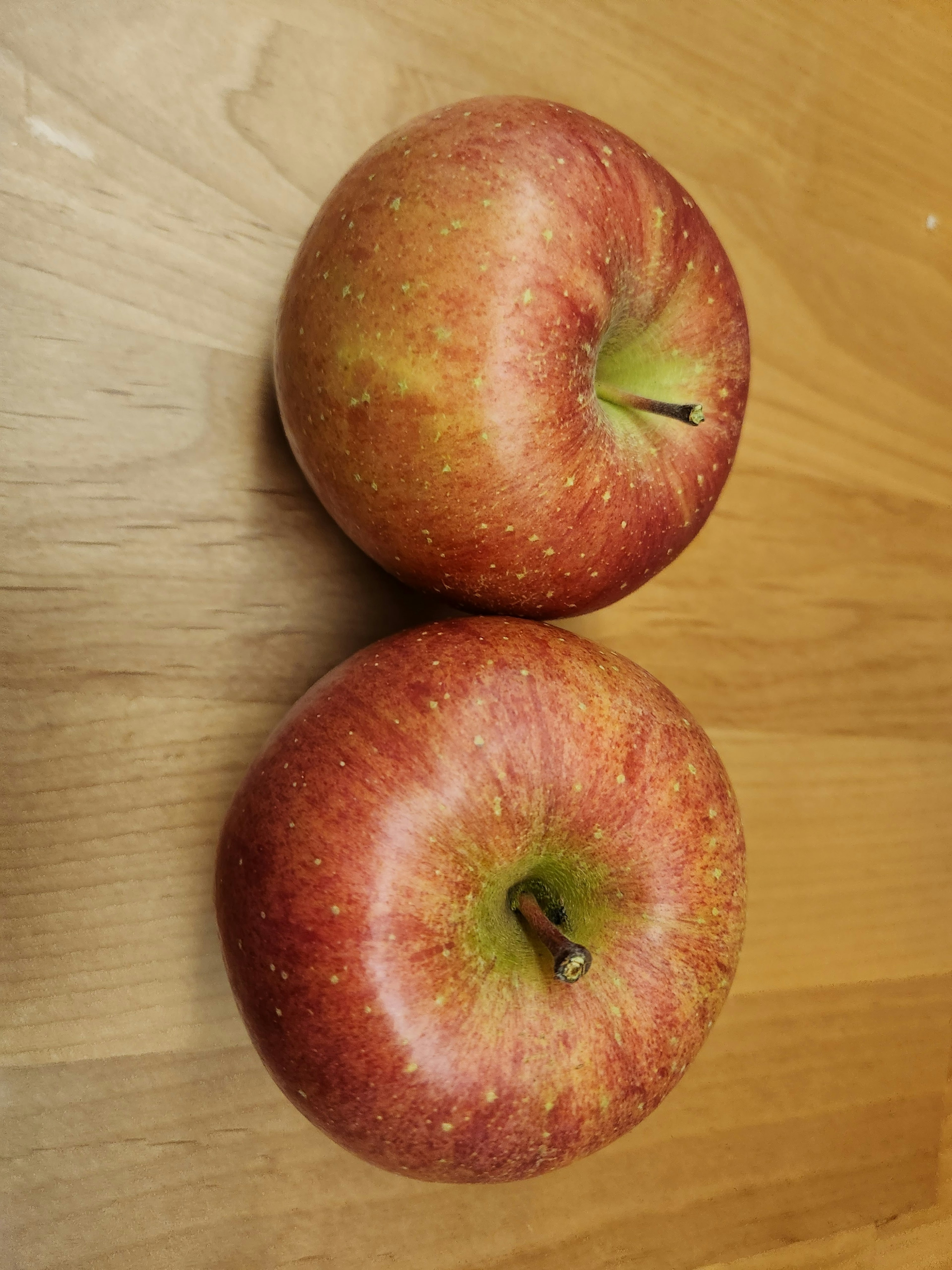 Deux pommes rouges sur une table en bois