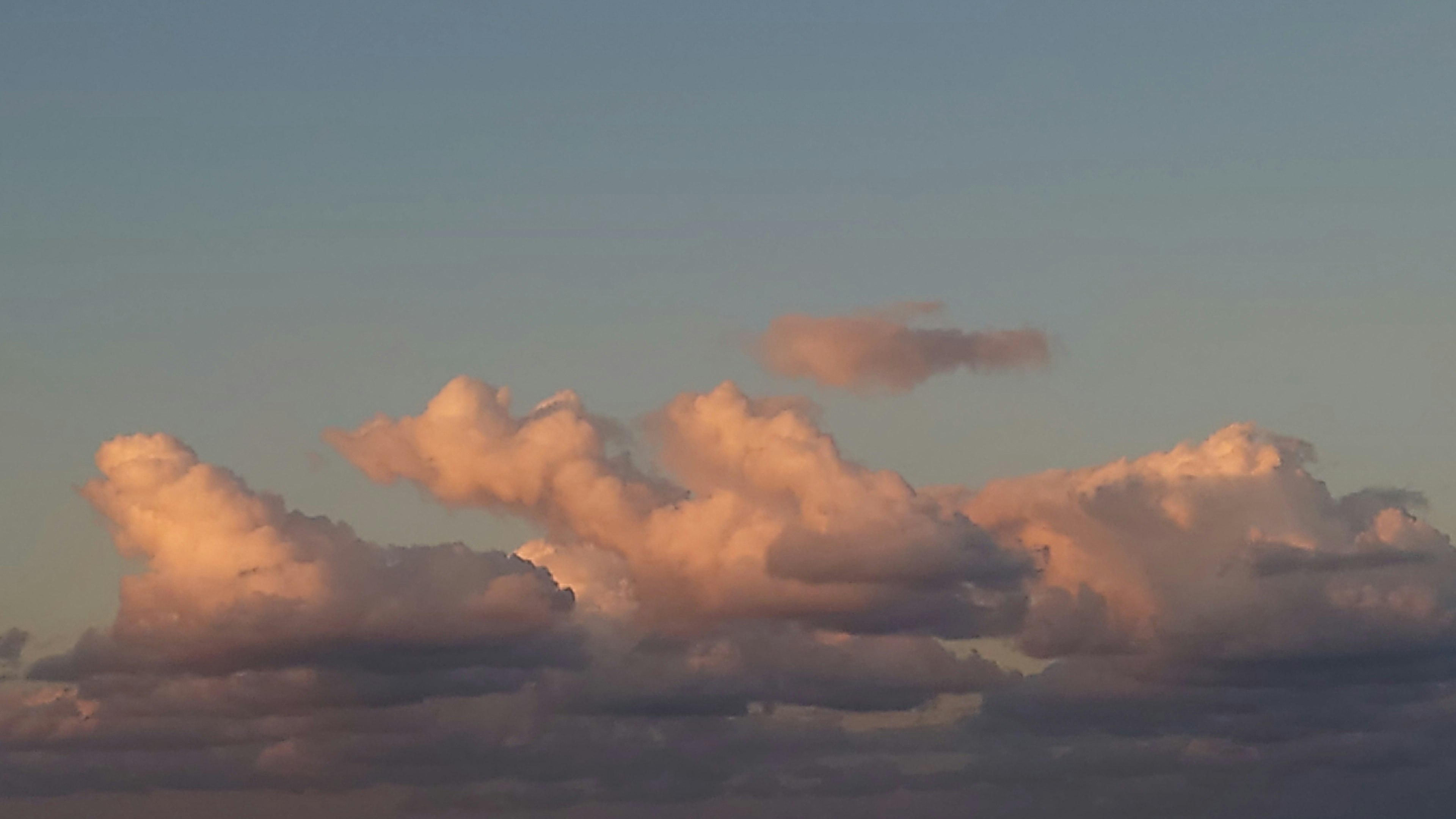 柔軟的雲朵漂浮在天空中，背景是柔和的藍色