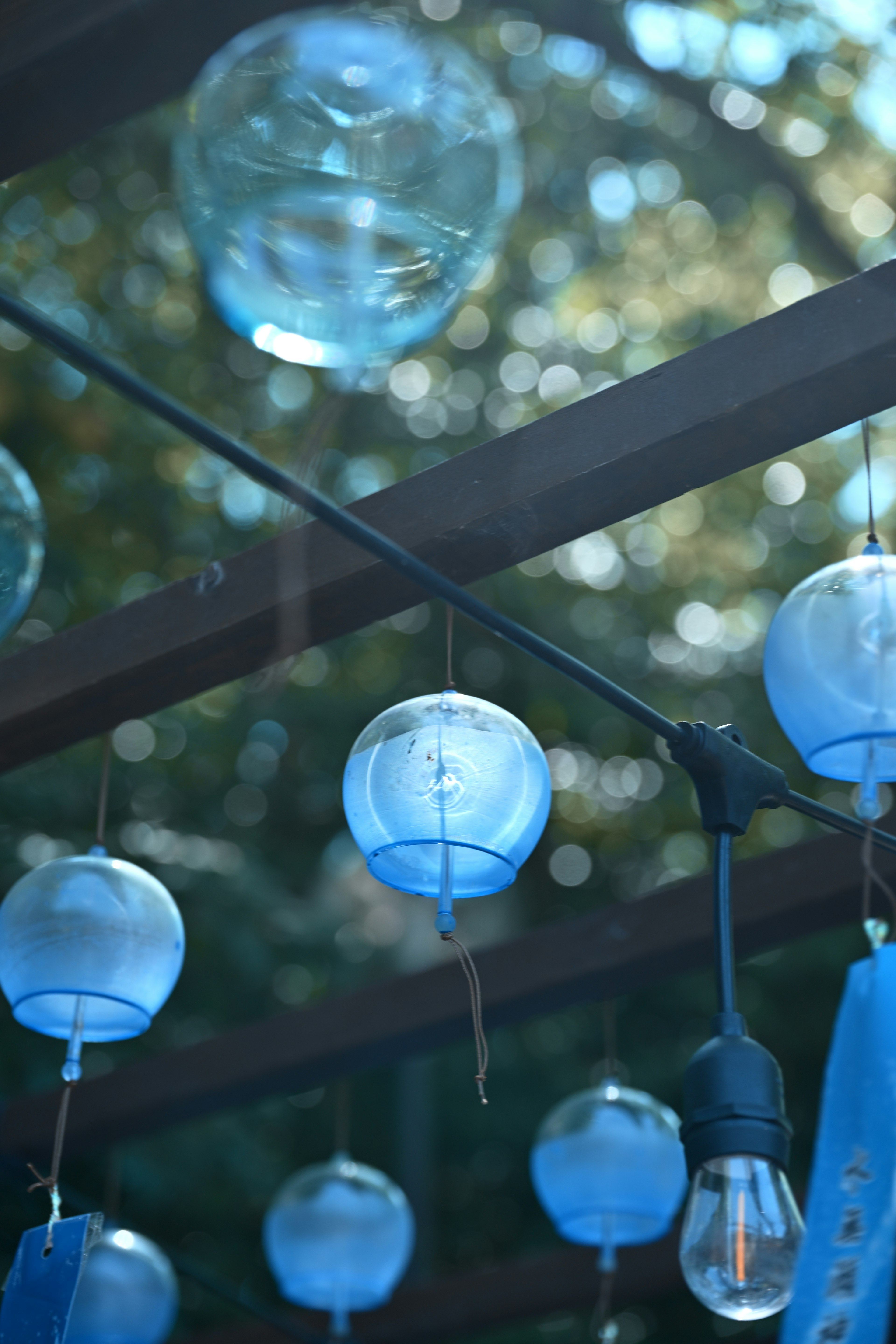 Outdoor scene featuring blue glass wind chimes hanging