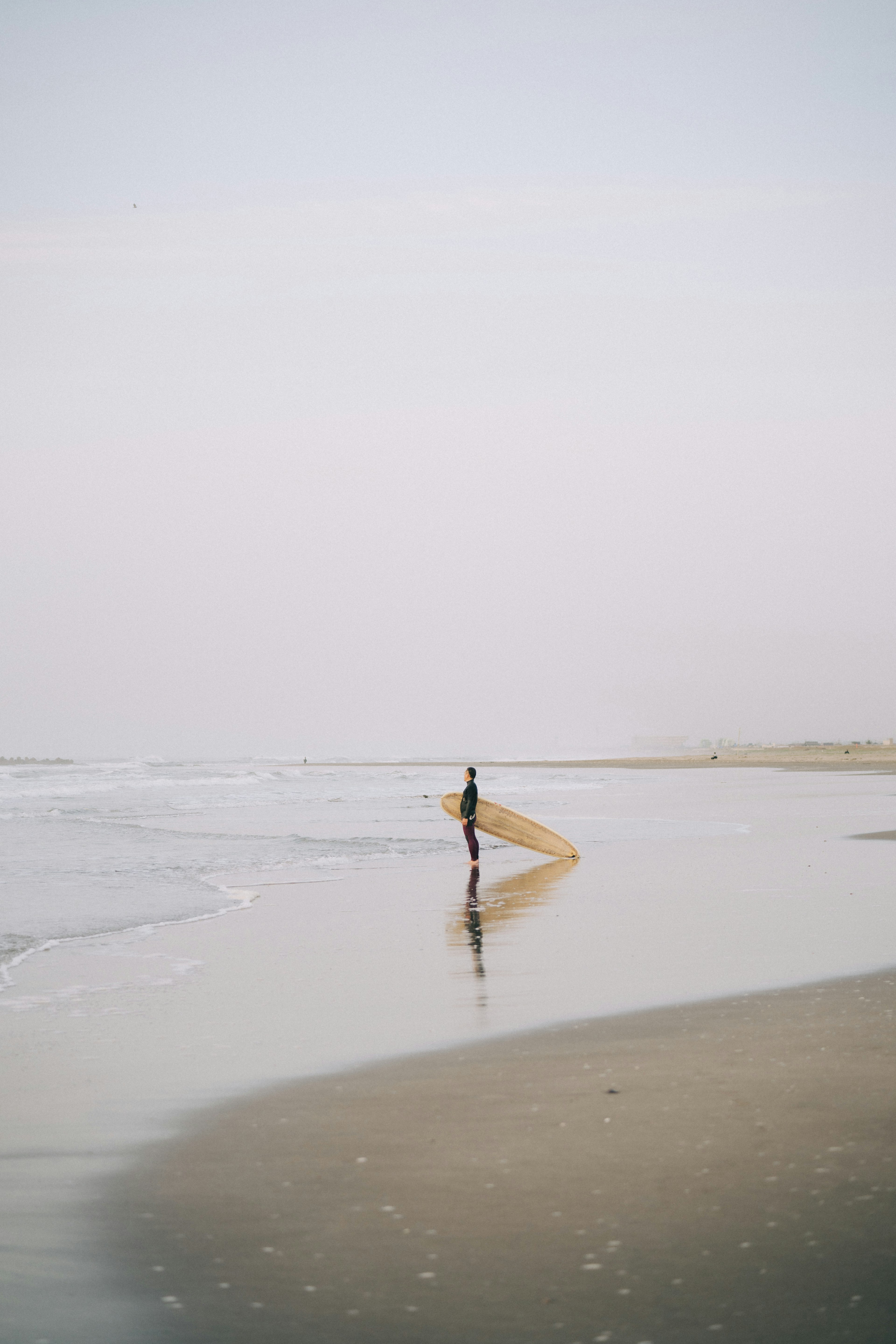 เงาของคนที่ถือกระดานโต้คลื่นที่ชายหาด