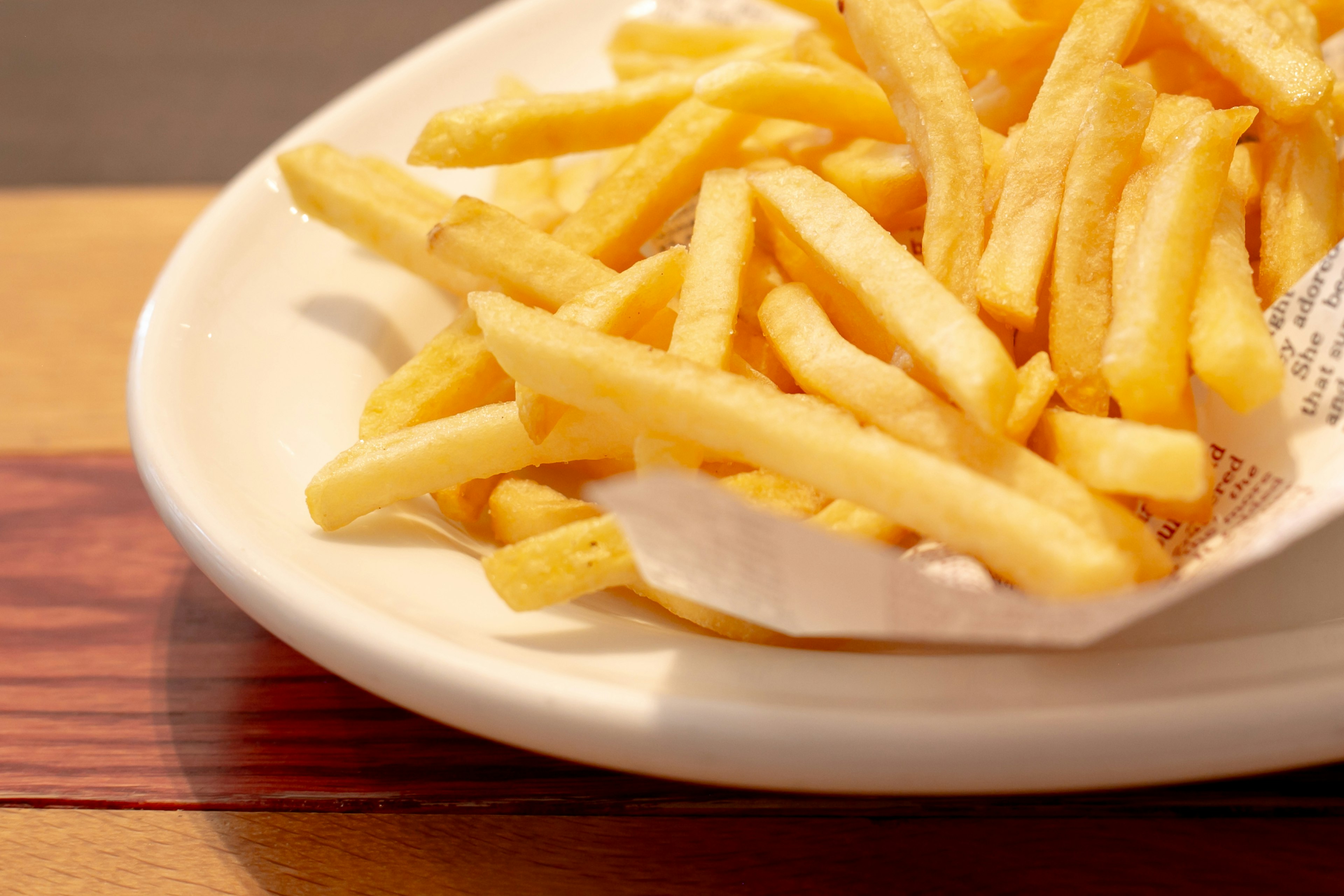 Ein Teller knuspriger goldener Pommes Frites auf einem Holztisch