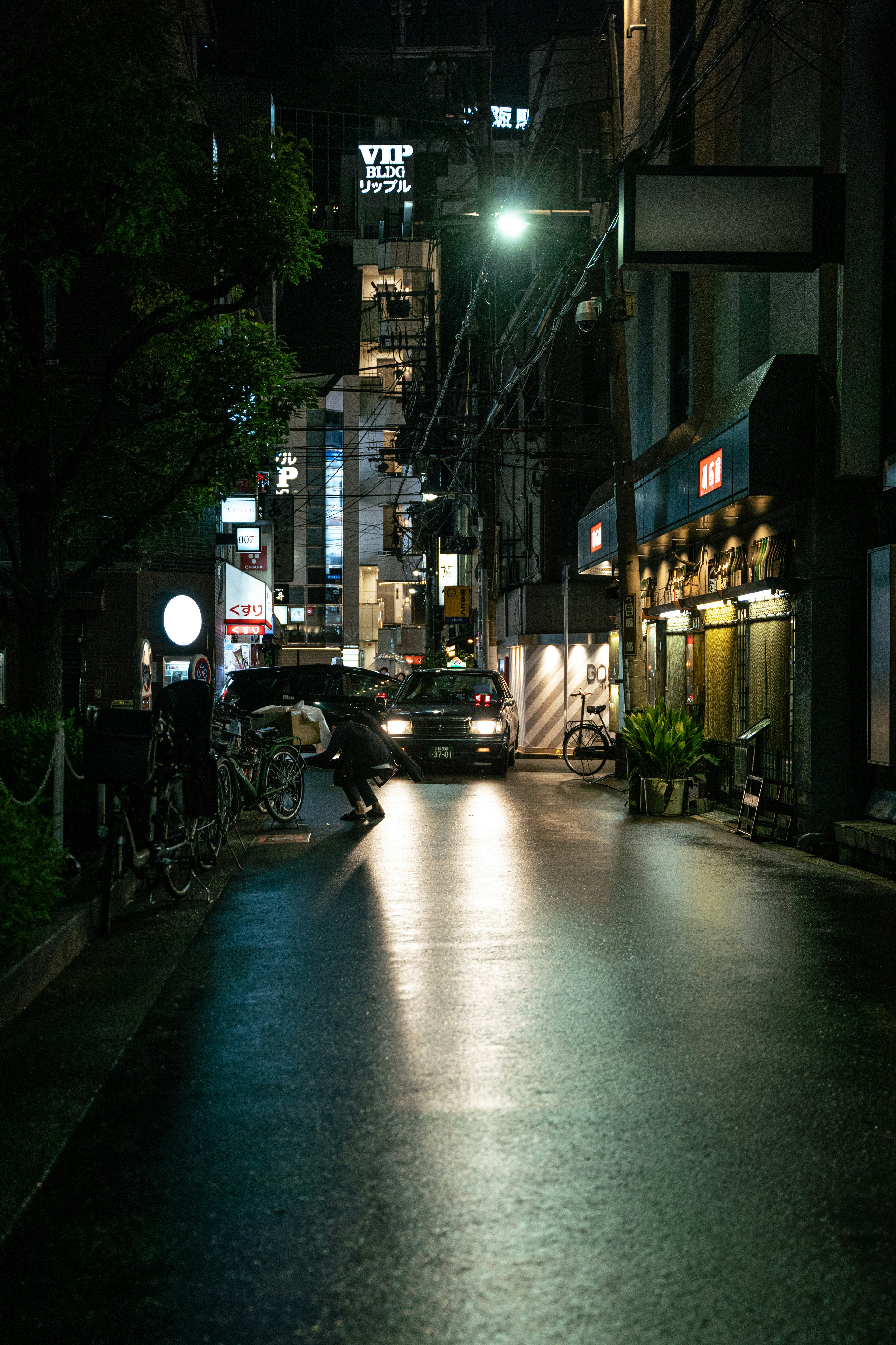 Calle de la ciudad iluminada por la noche con pavimento brillante y letreros