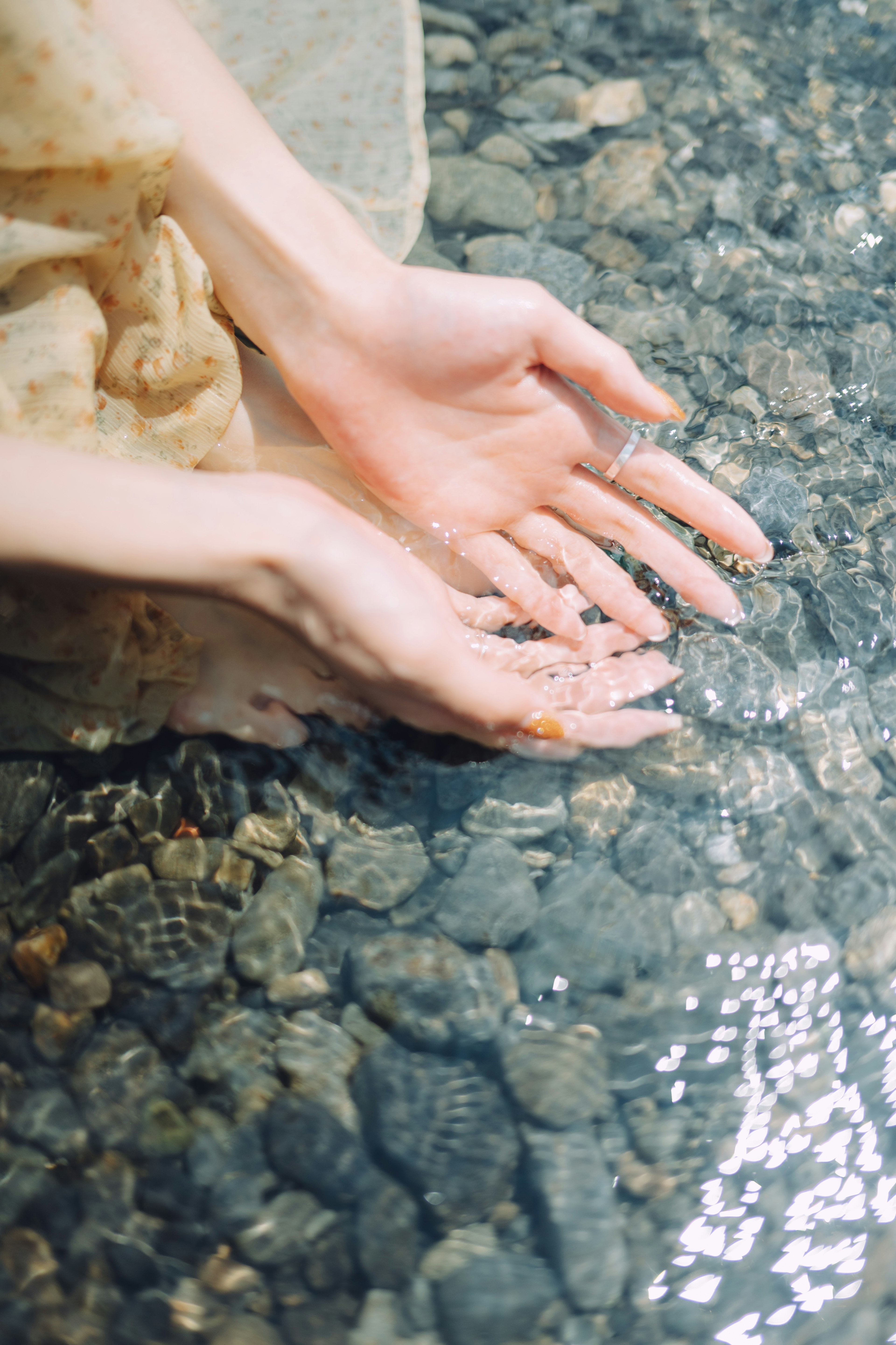 水の中に手を浸している女性の手のクローズアップ