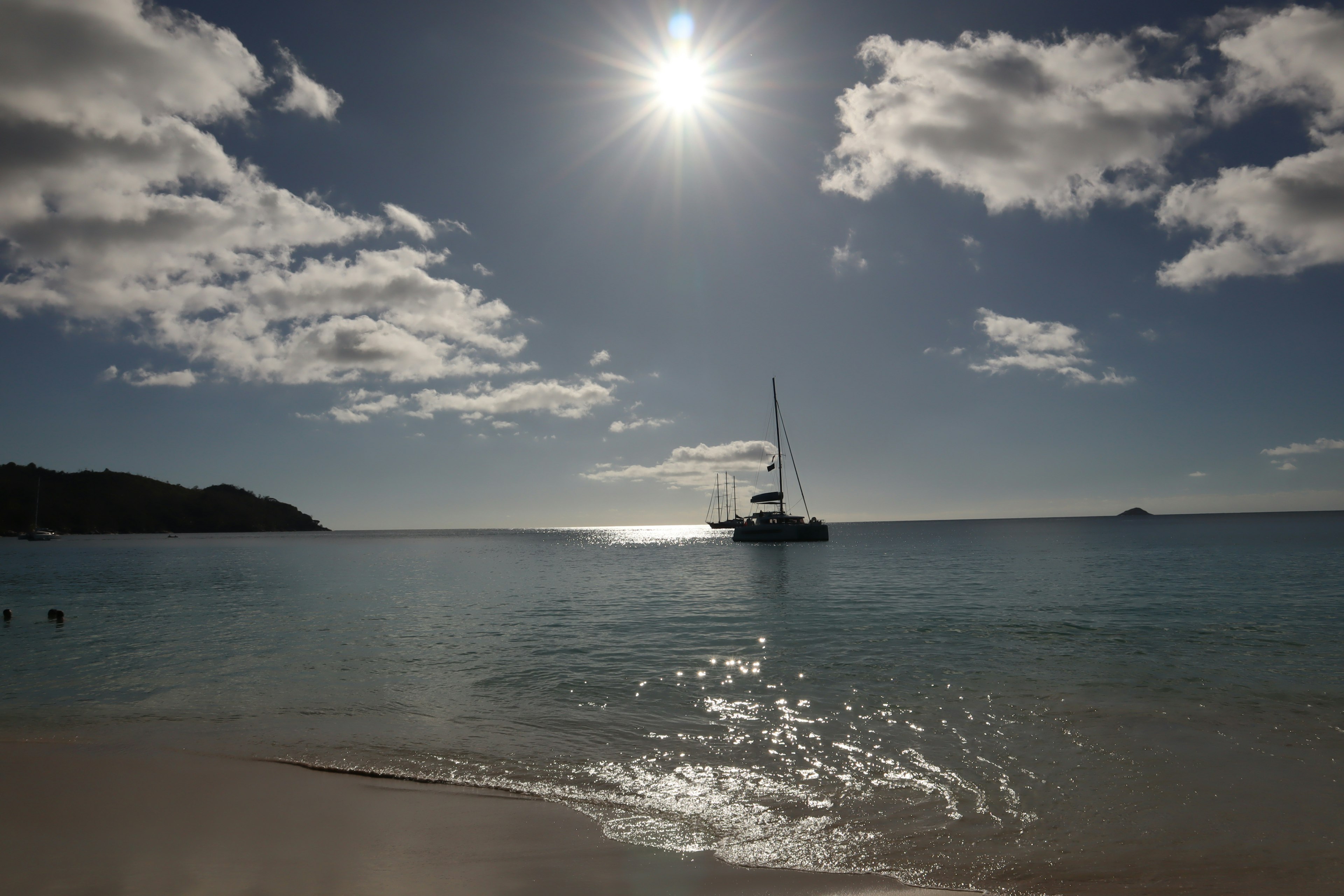 Schöne Strandlandschaft mit blauem Meer weißem Sand Wolken am Himmel und strahlender Sonne