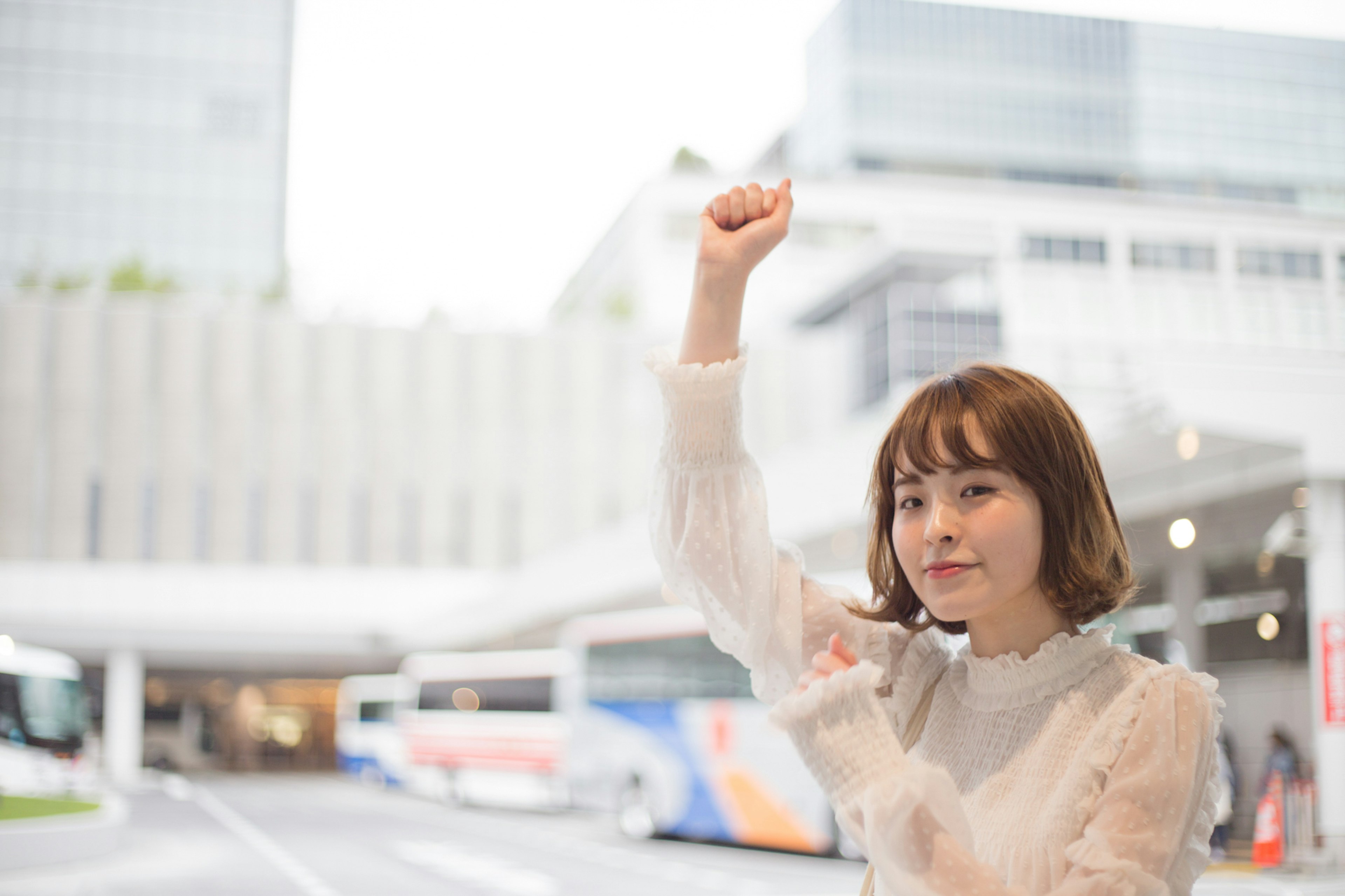 A woman raising her hand in an urban setting