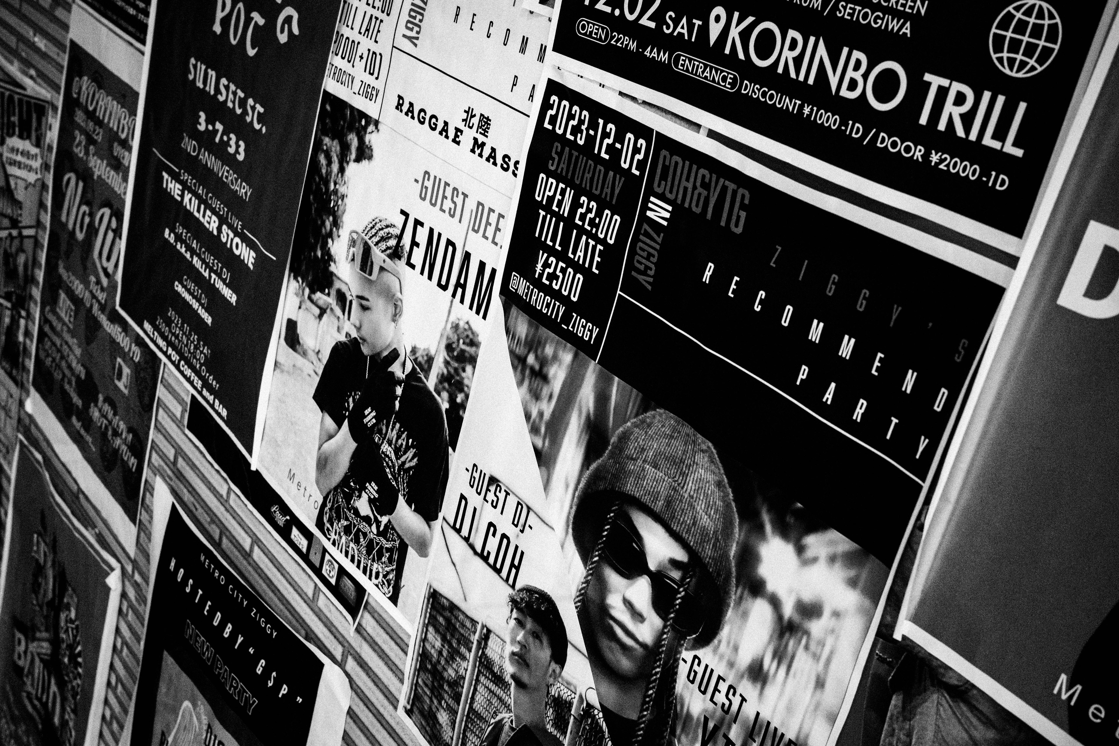 A wall covered with black and white posters featuring various designs and text