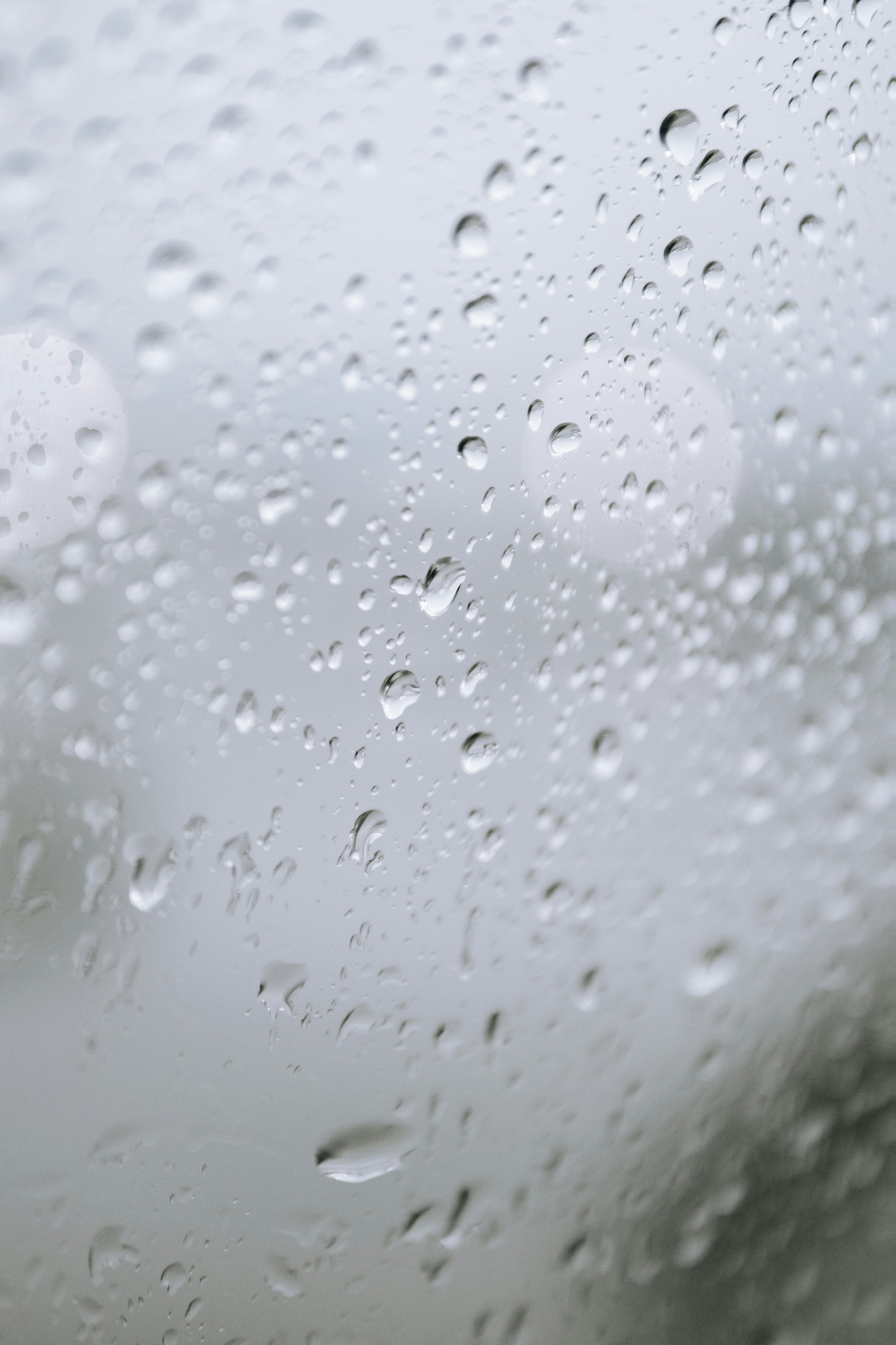 窗户上的雨滴特写，背景模糊