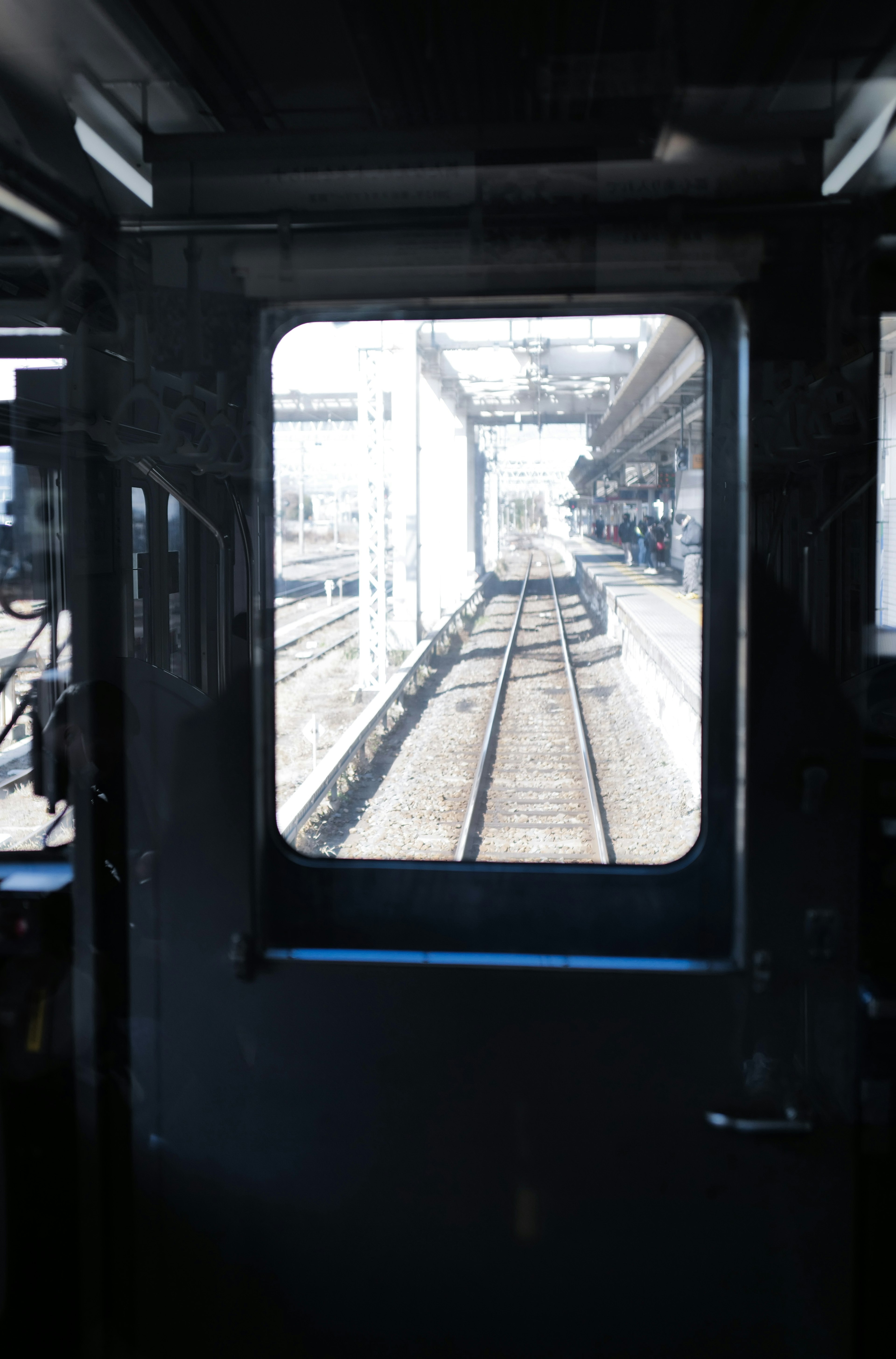 View from a train driver's seat showing tracks and station structures