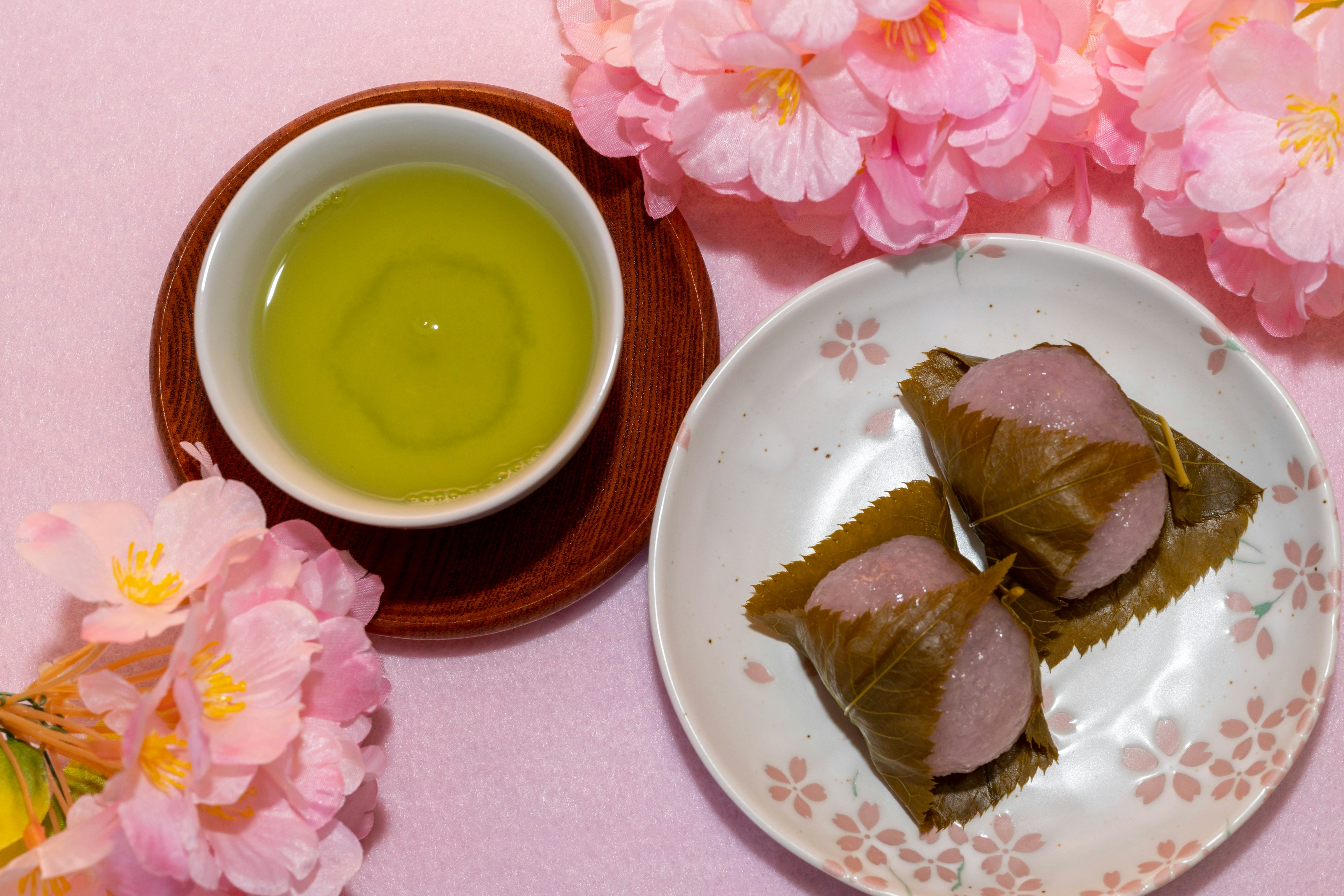 Schöne Anordnung von Kirschblüten, Tee und japanischen Süßigkeiten