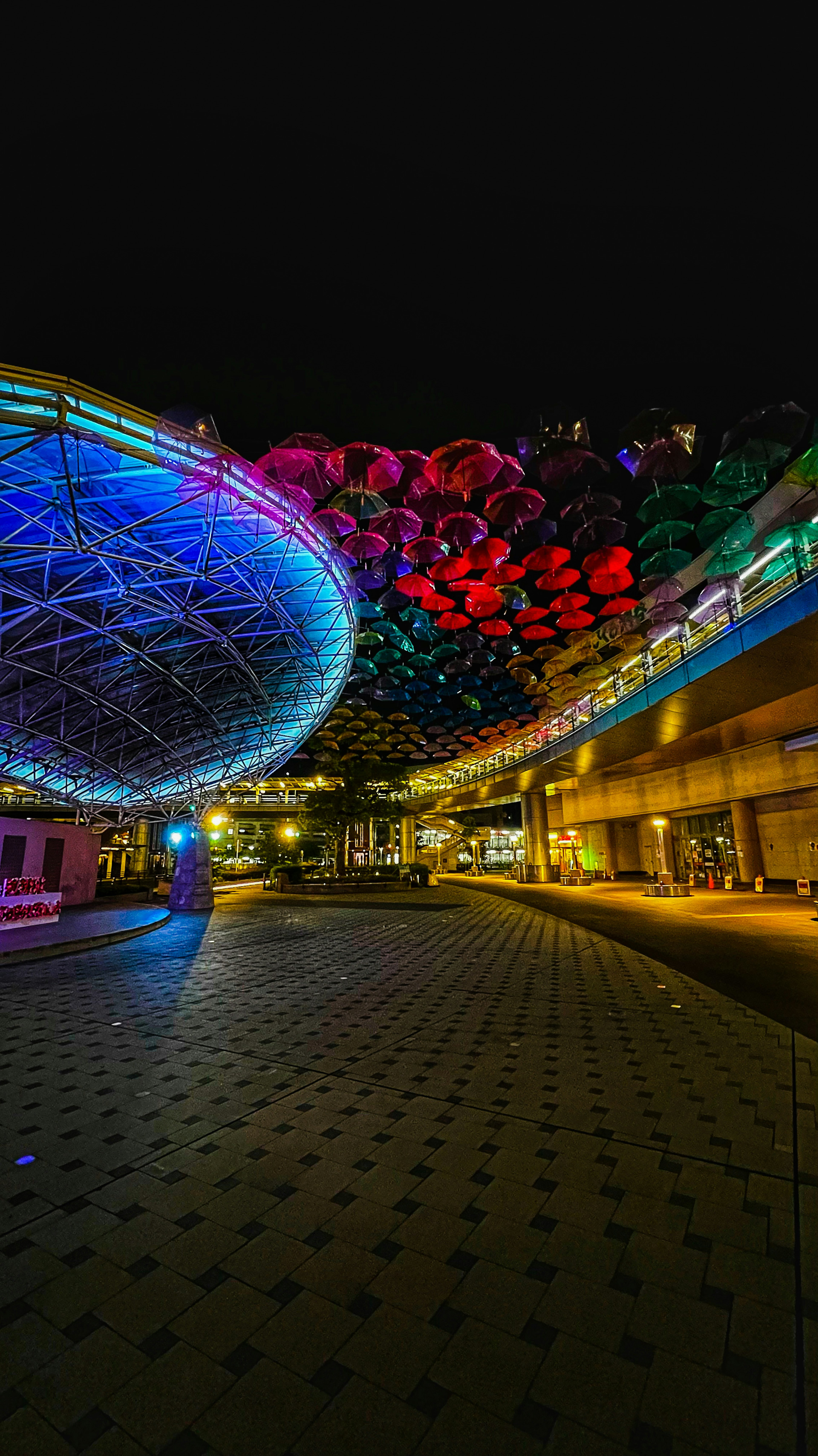 Scena notturna vibrante di una piazza illuminata con luci colorate