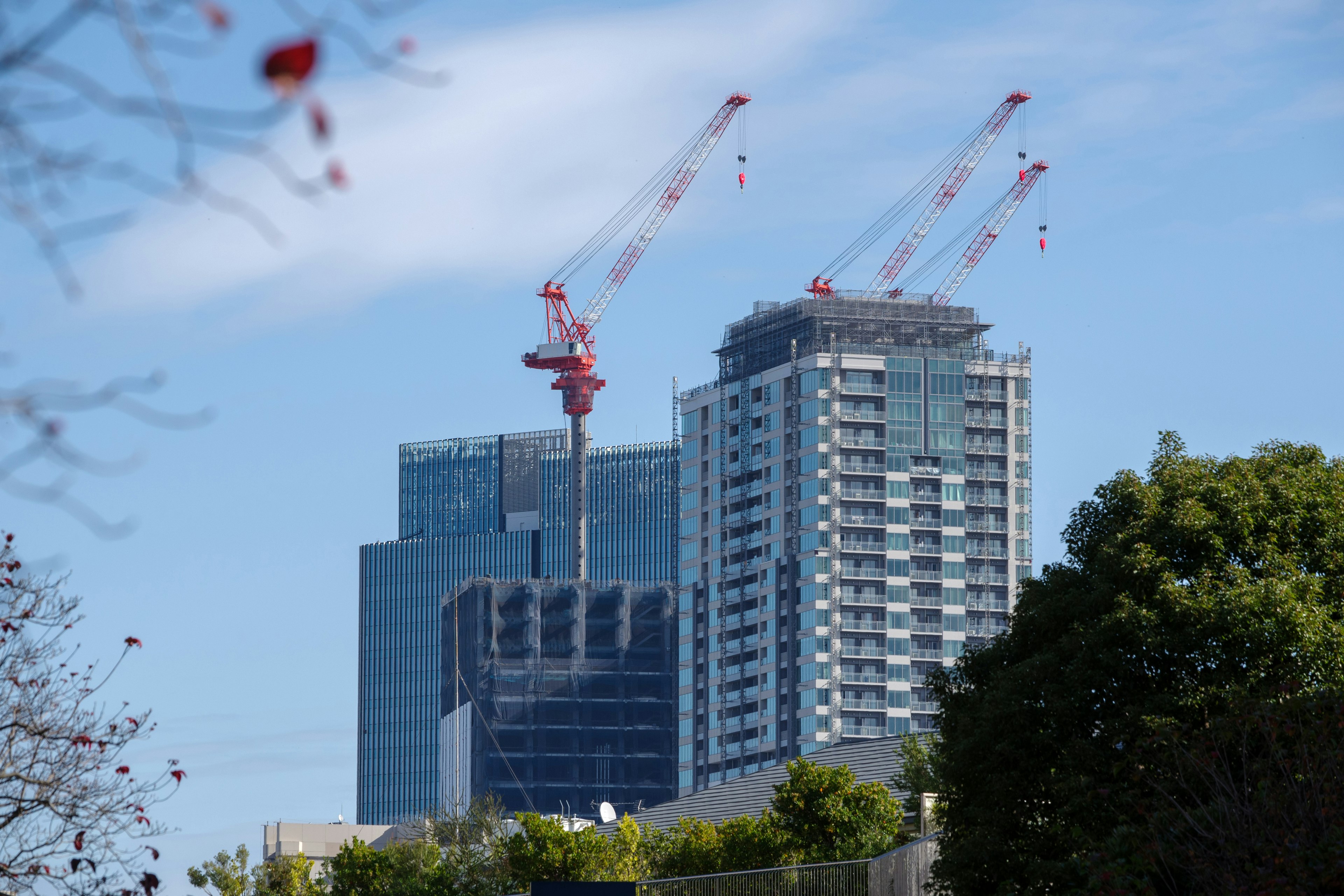 Urban skyline featuring a construction site with cranes and high-rise buildings