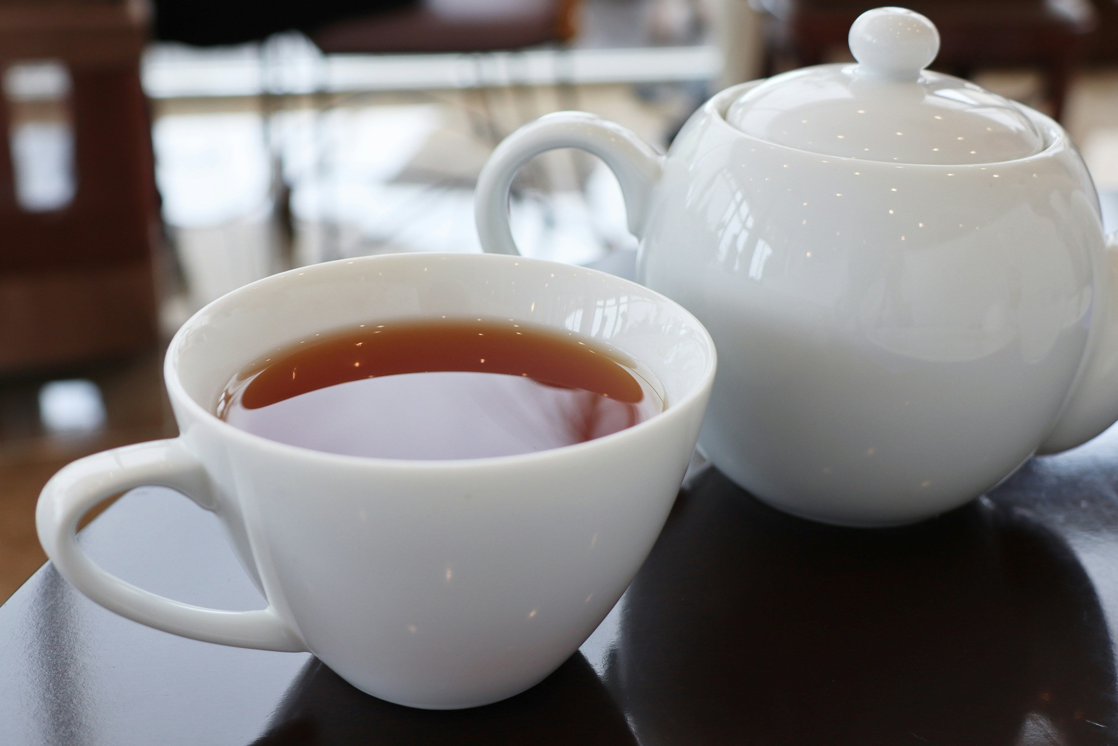 Weiße Tasse und Teekanne mit aufgebrühtem Tee