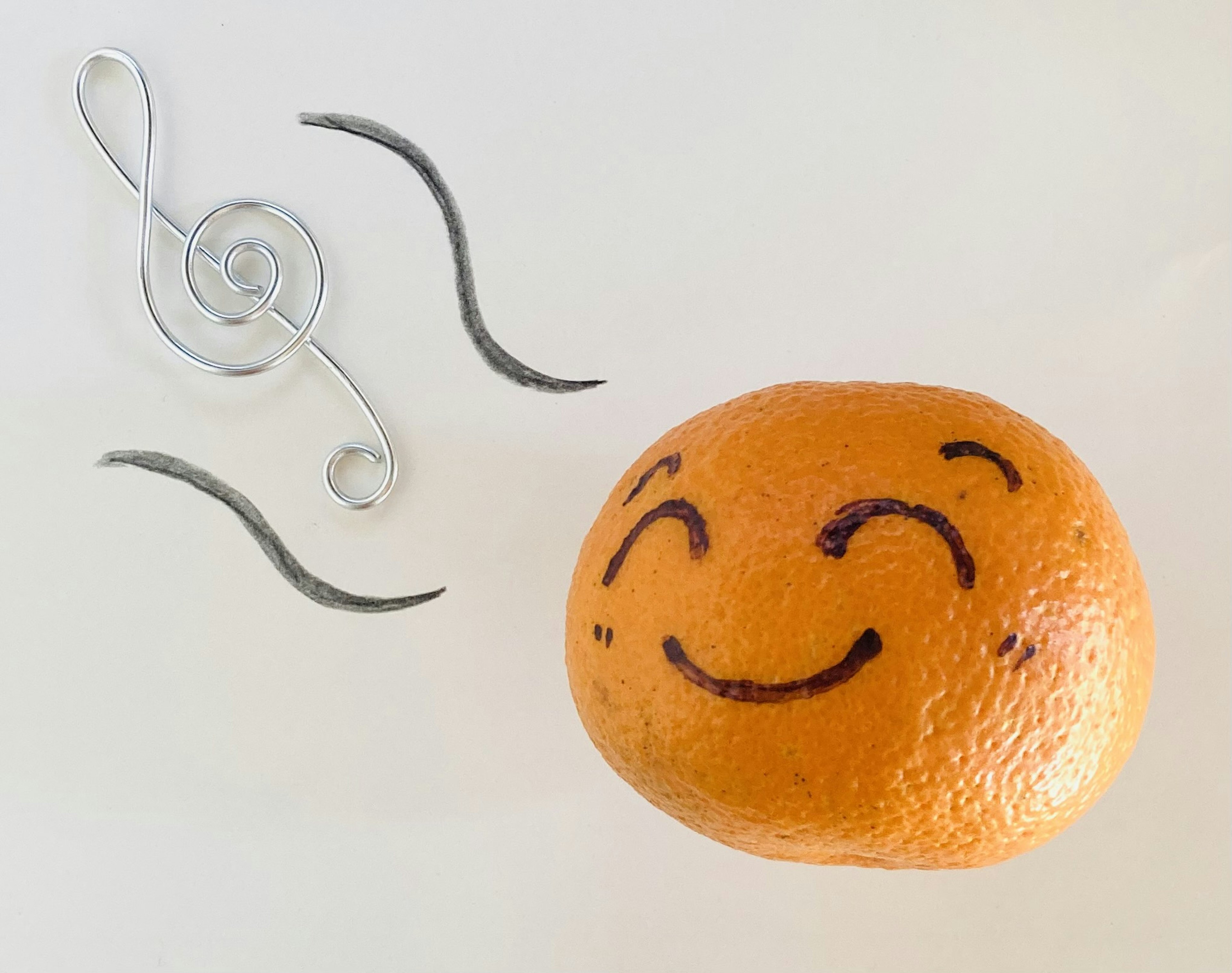 Naranja sonriente con notas musicales