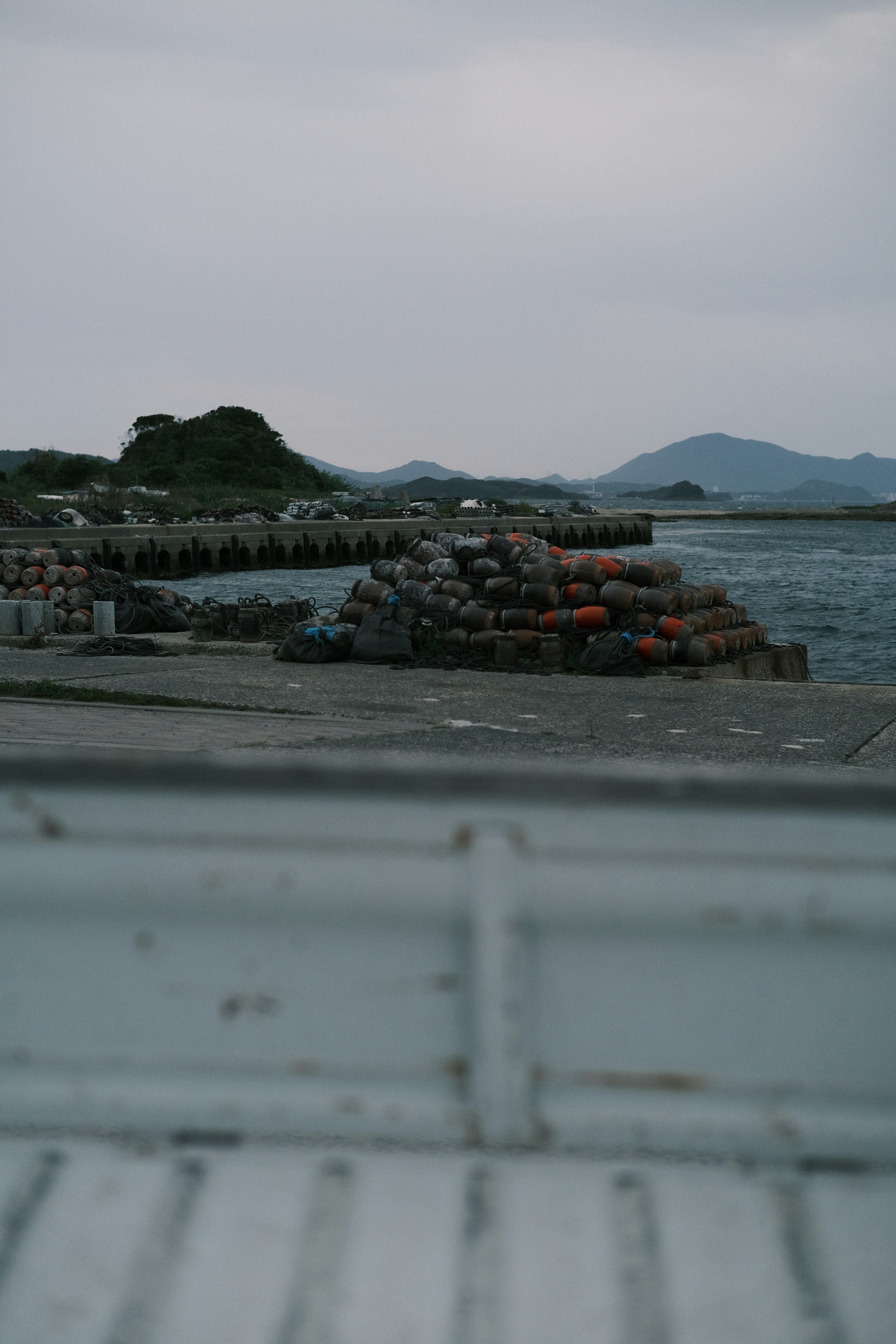 해안에 쌓인 다채로운 보트와 멀리 보이는 산들