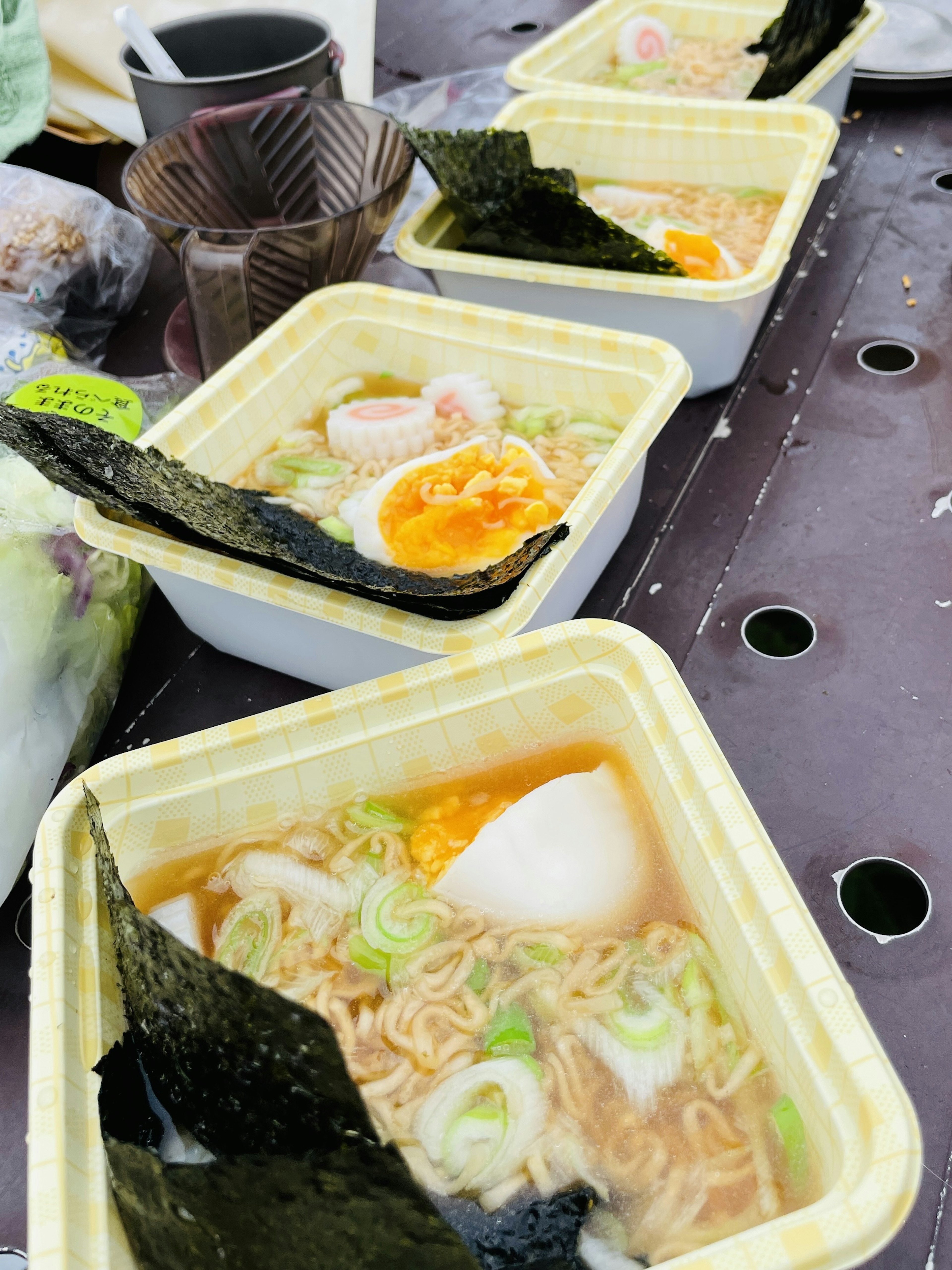 Ramen caldo in contenitori con uova e cipollotti