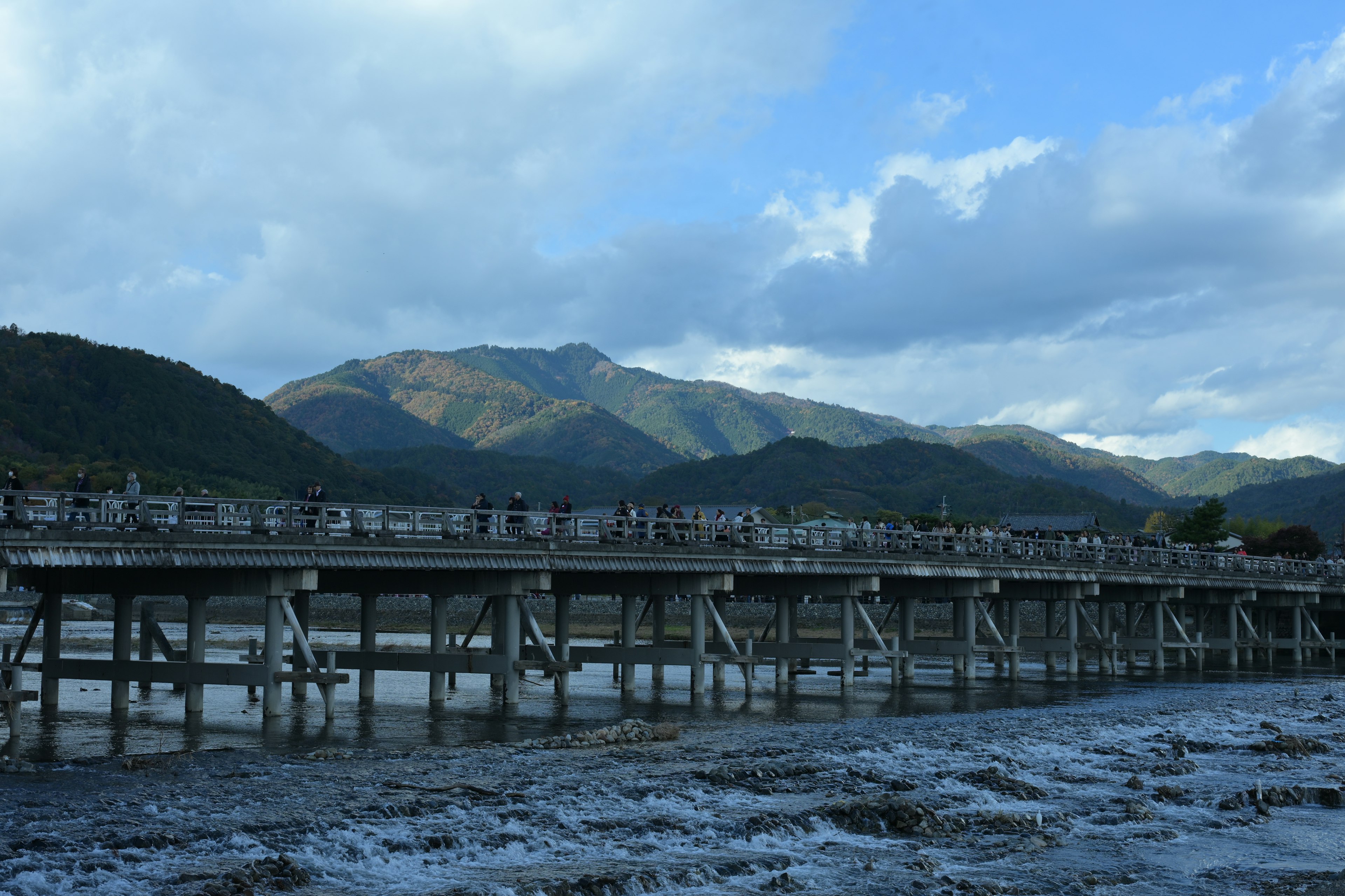 山々を背景にした木製の橋と川の風景