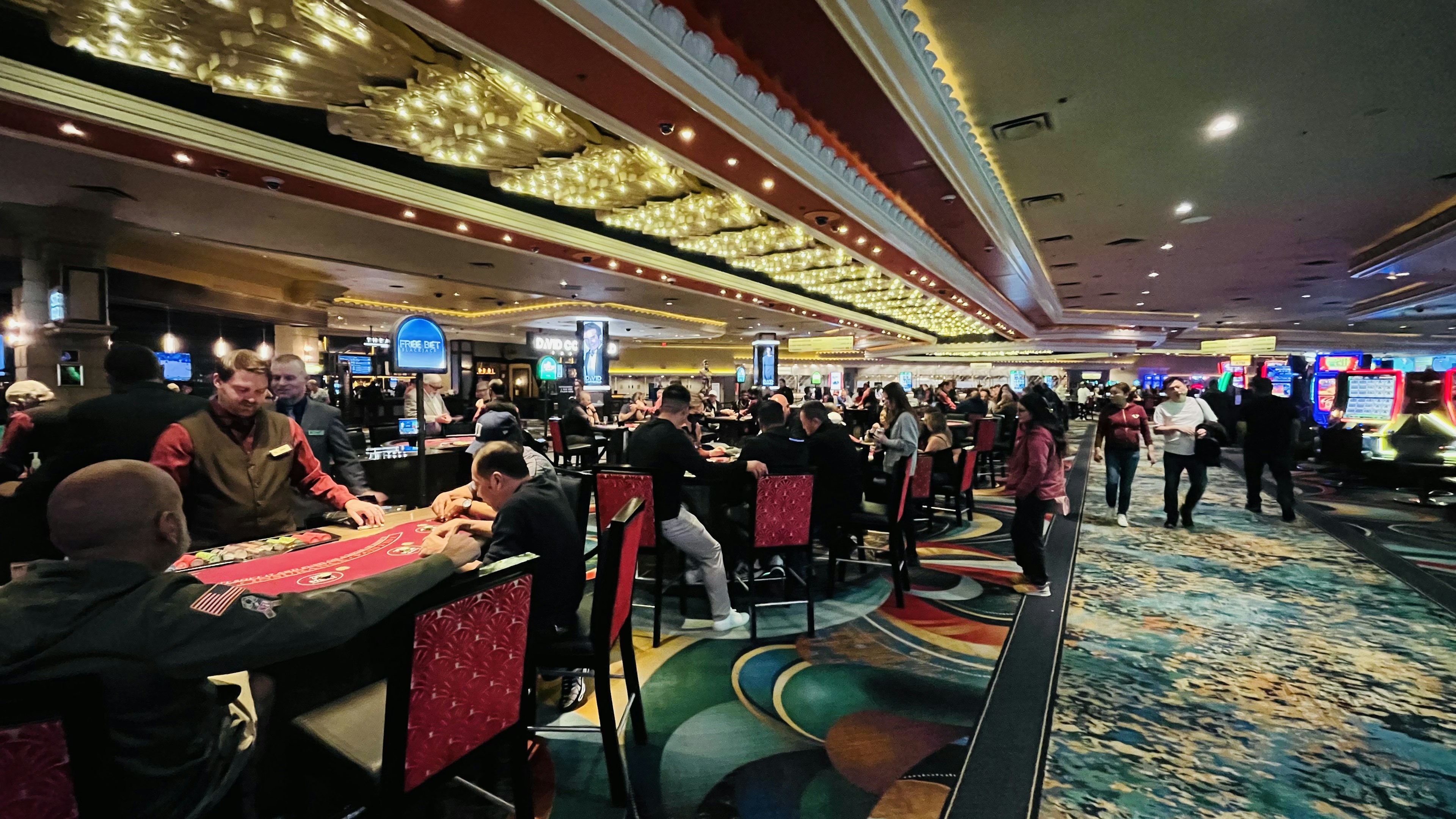 Interior de un casino con muchas personas disfrutando de los juegos