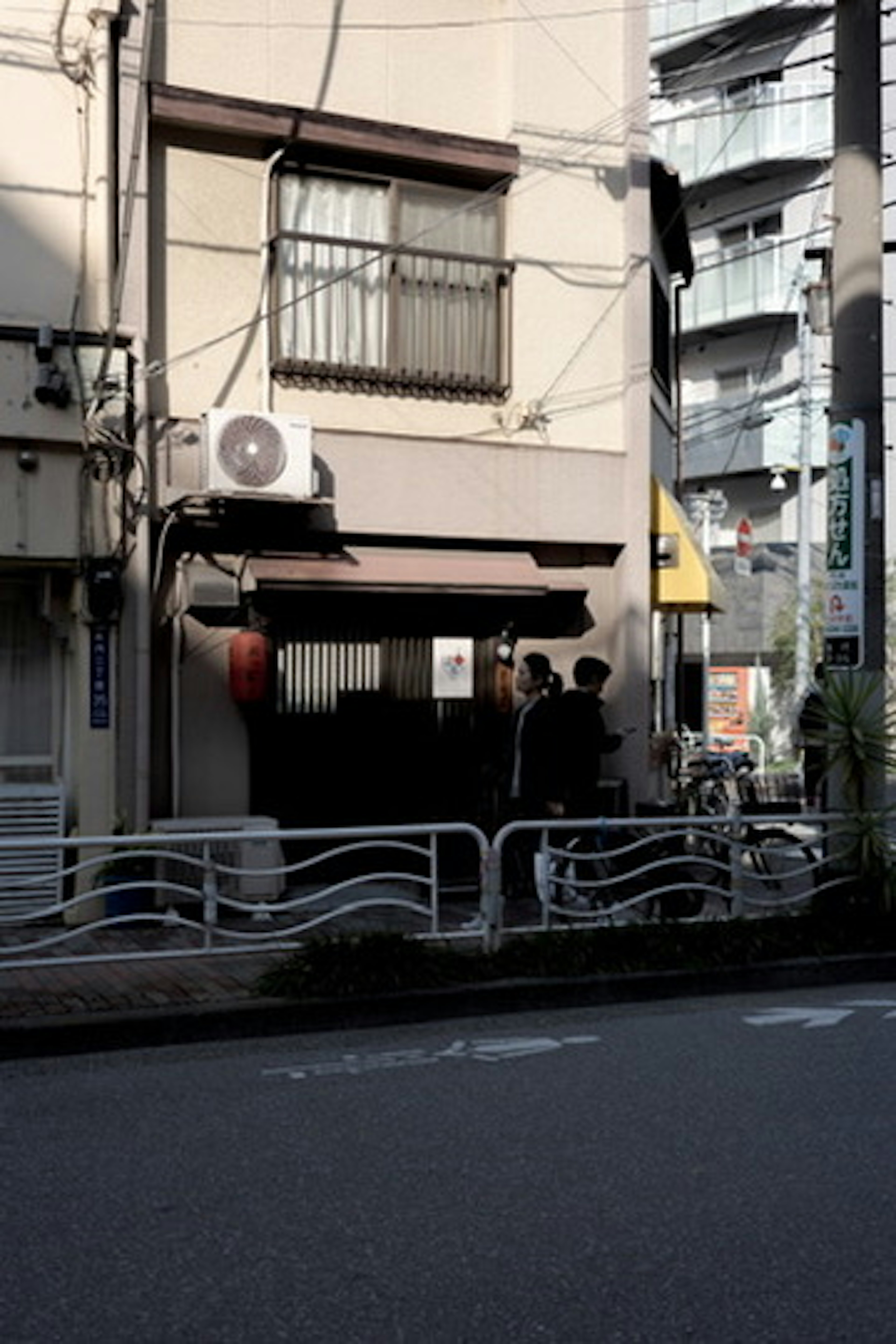 狭い通りに面した小さな日本の飲食店の外観