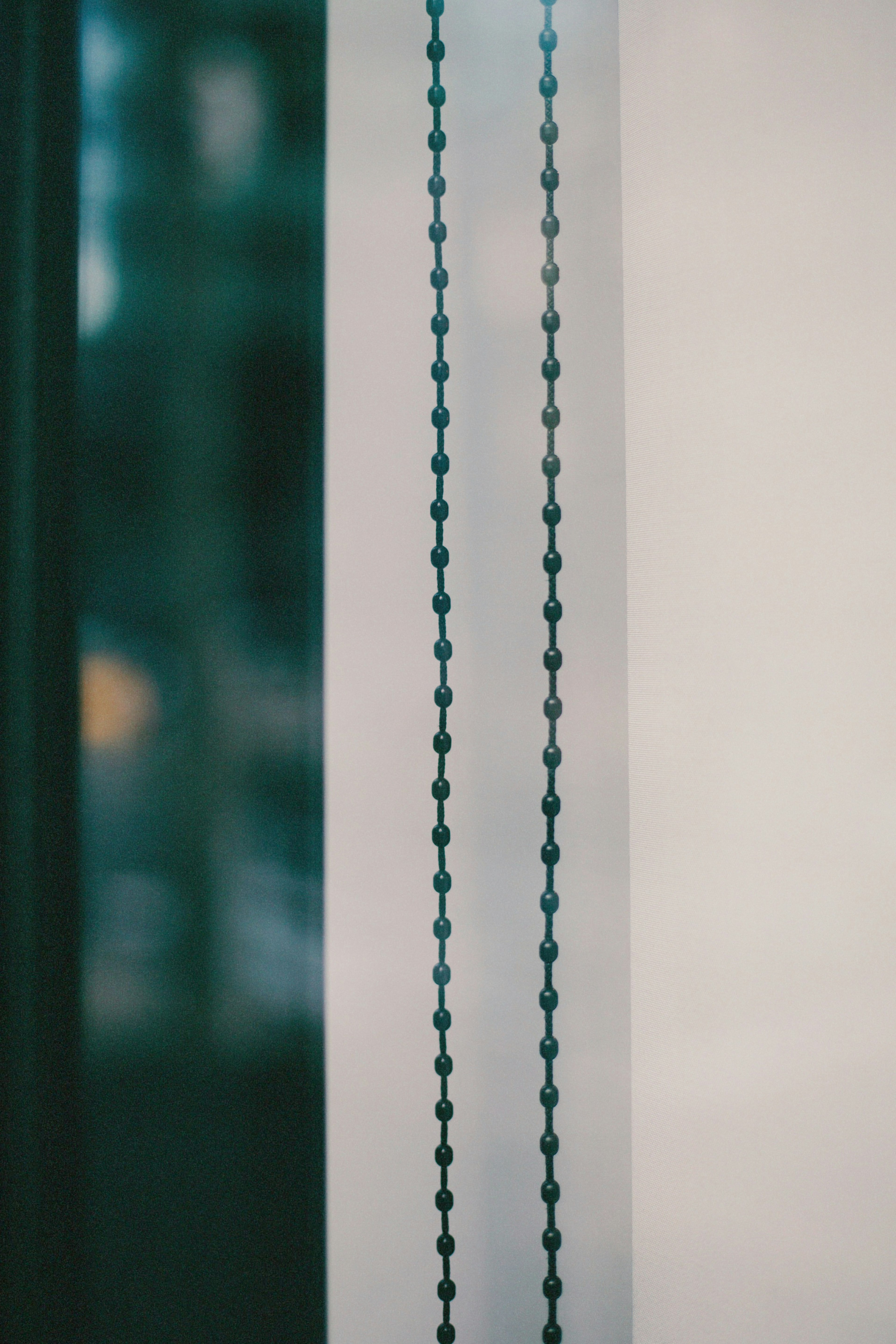 Imagen de una ventana con cadenas de cortina de cuentas negras colgando