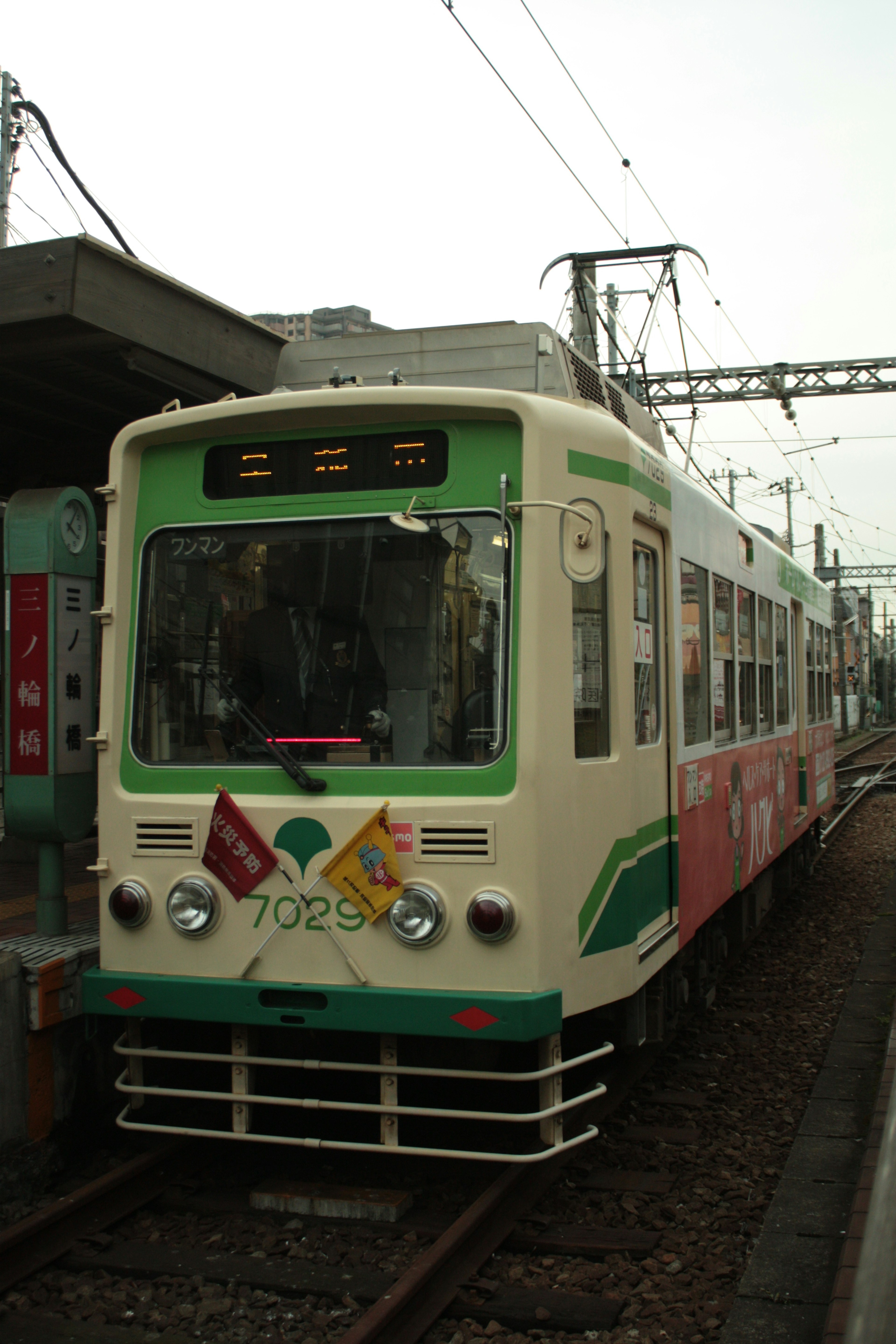 รถไฟสีเขียวและครีมจอดอยู่ที่สถานี