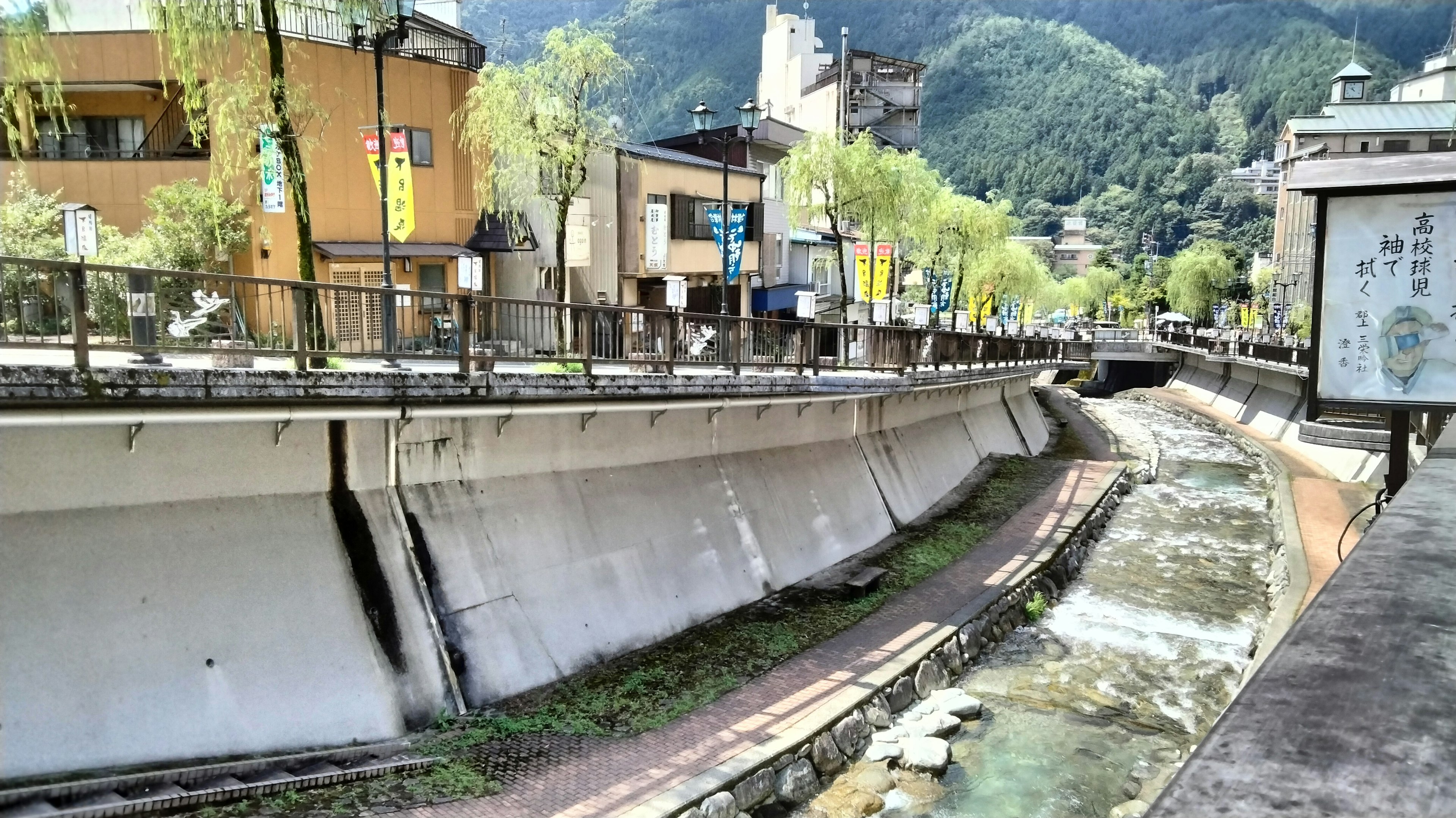 Una vista panoramica di un fiume con edifici lungo le sponde circondato da montagne