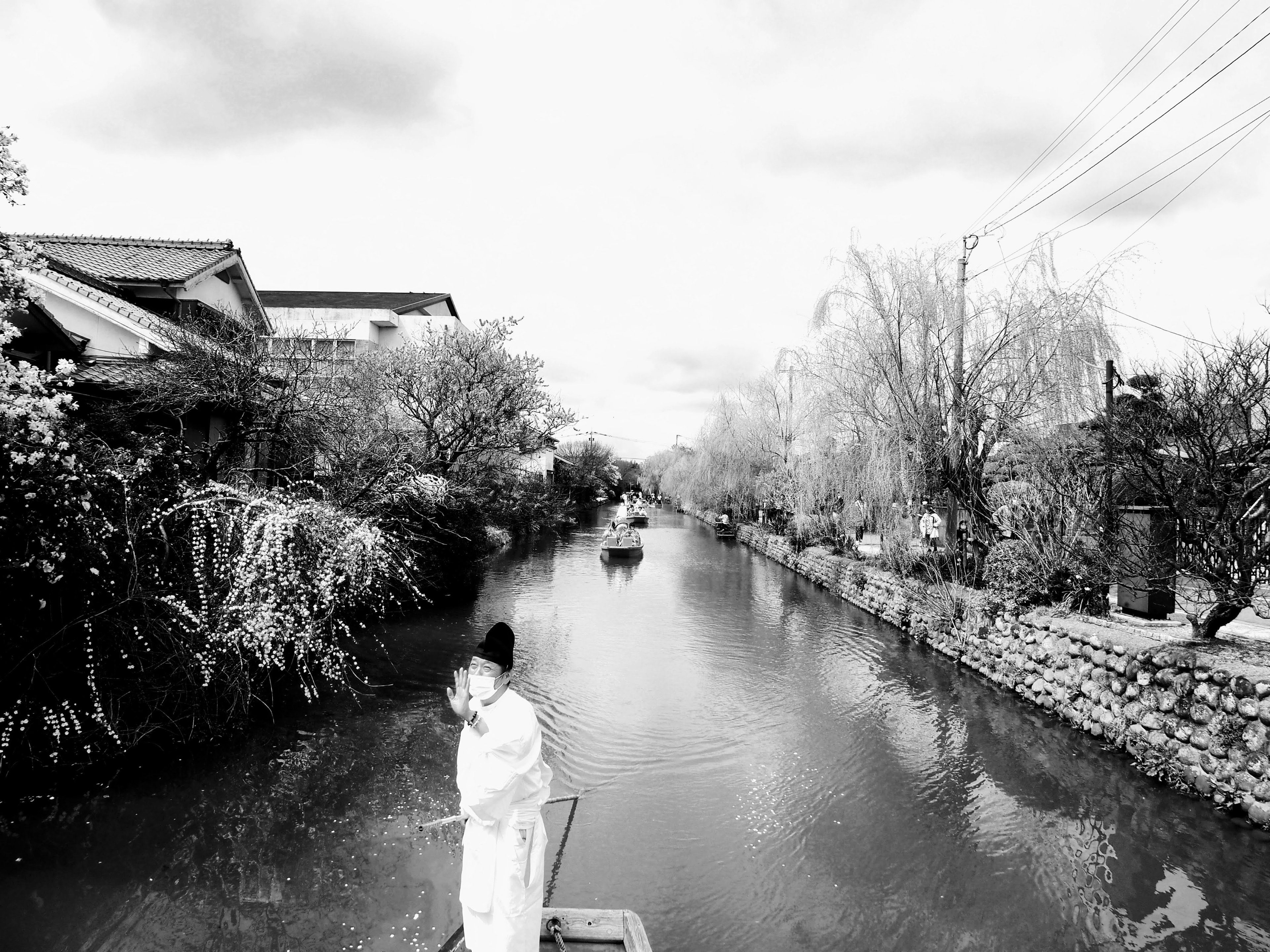 Imagen en blanco y negro de una persona en un bote en un río rodeado de naturaleza