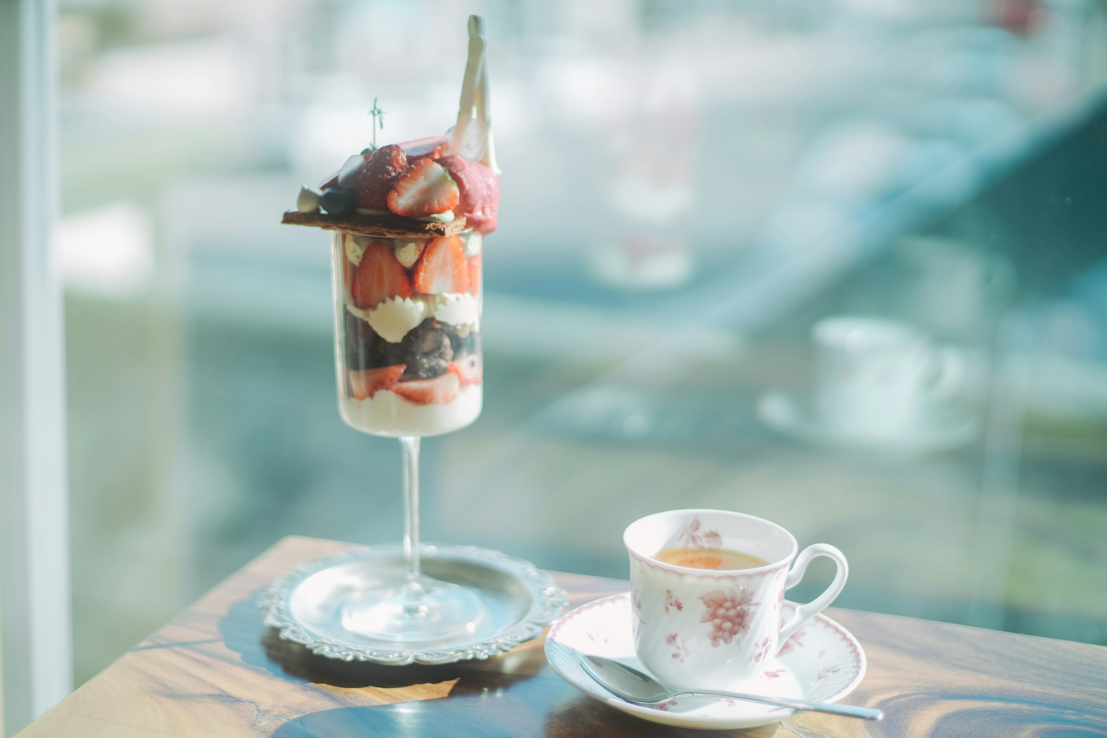 A beautiful parfait and teacup on a café table