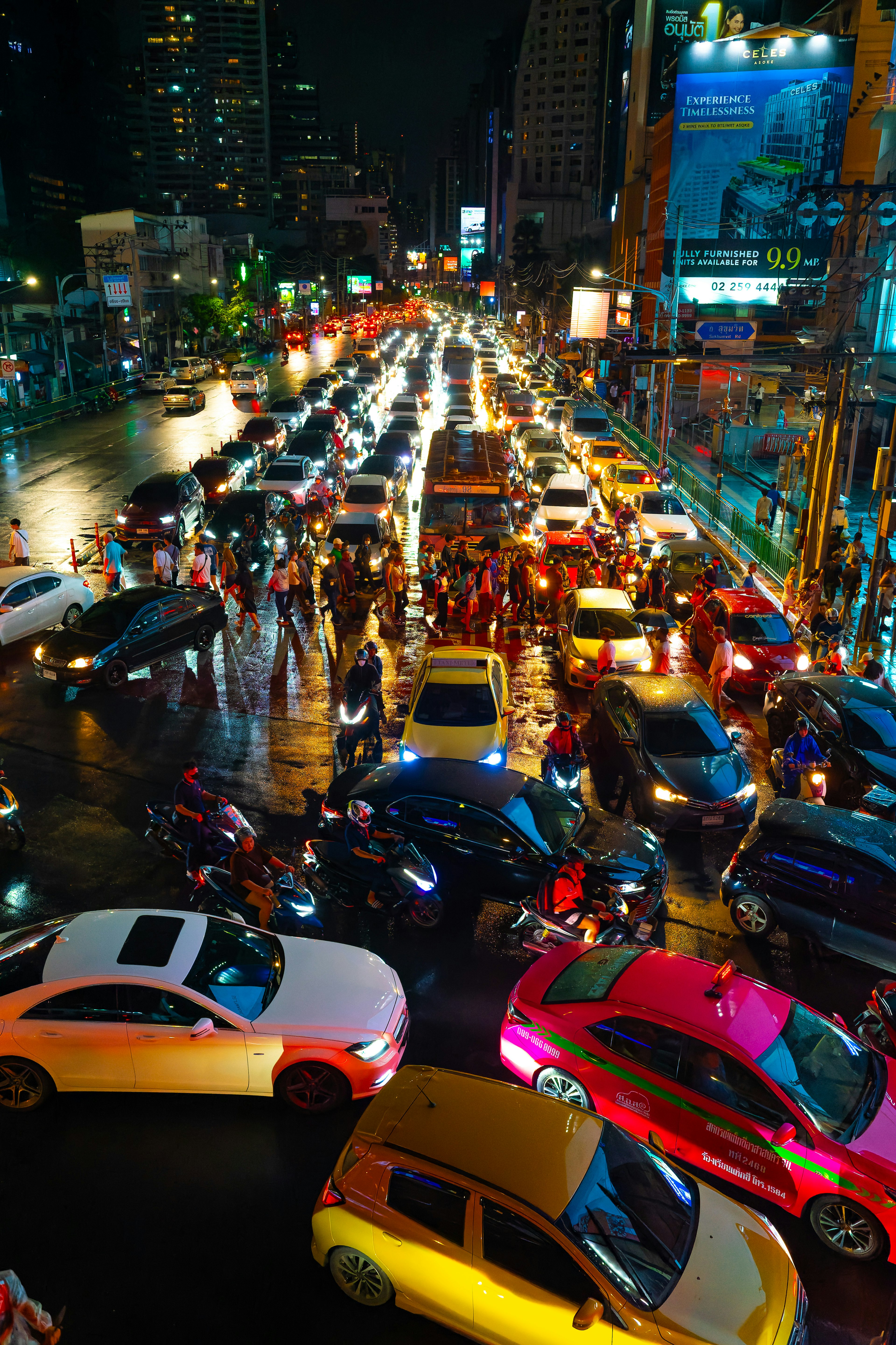 Nighttime urban traffic jam with numerous cars and motorcycles intersecting