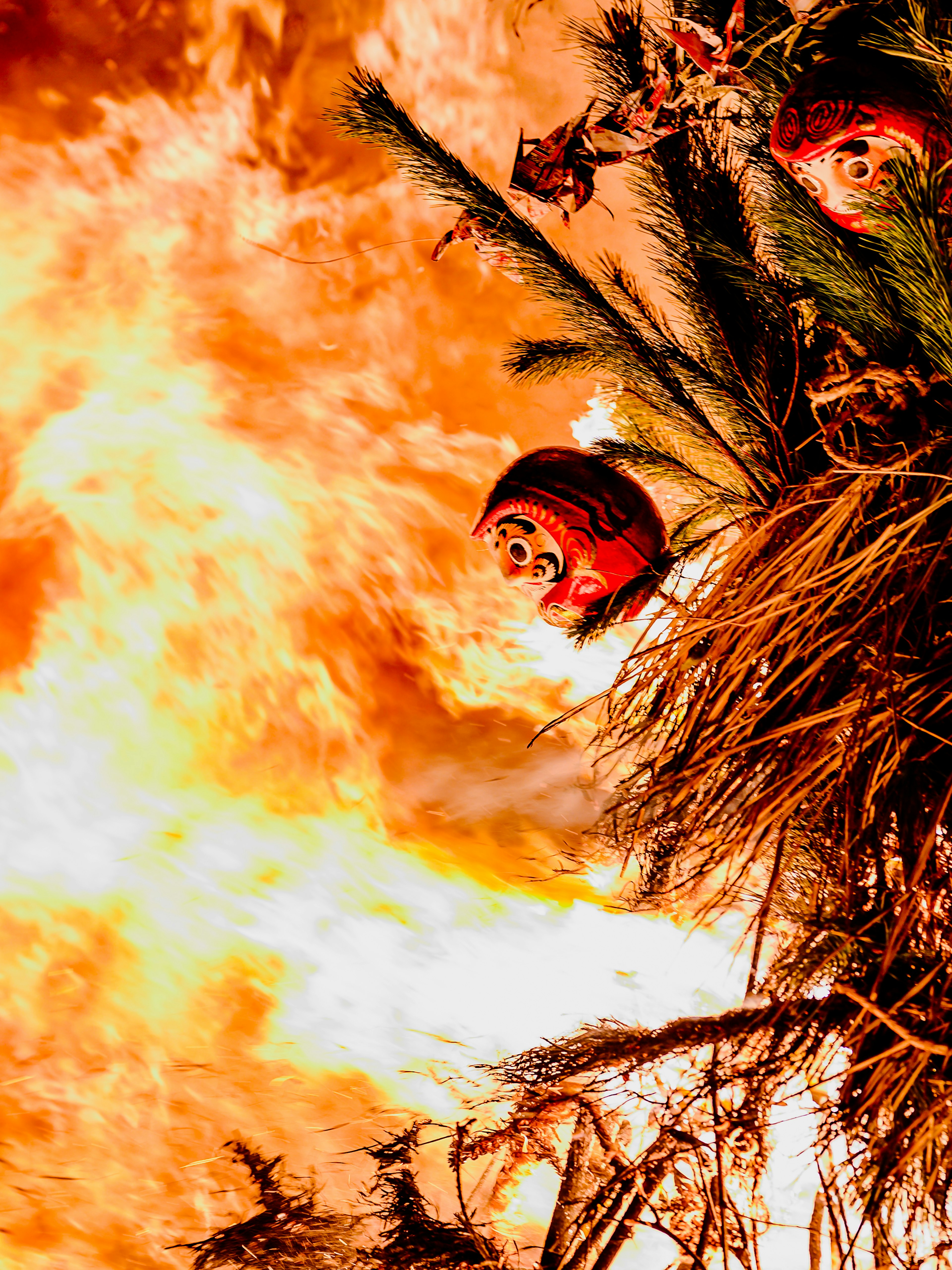 Red daruma dolls amidst flames