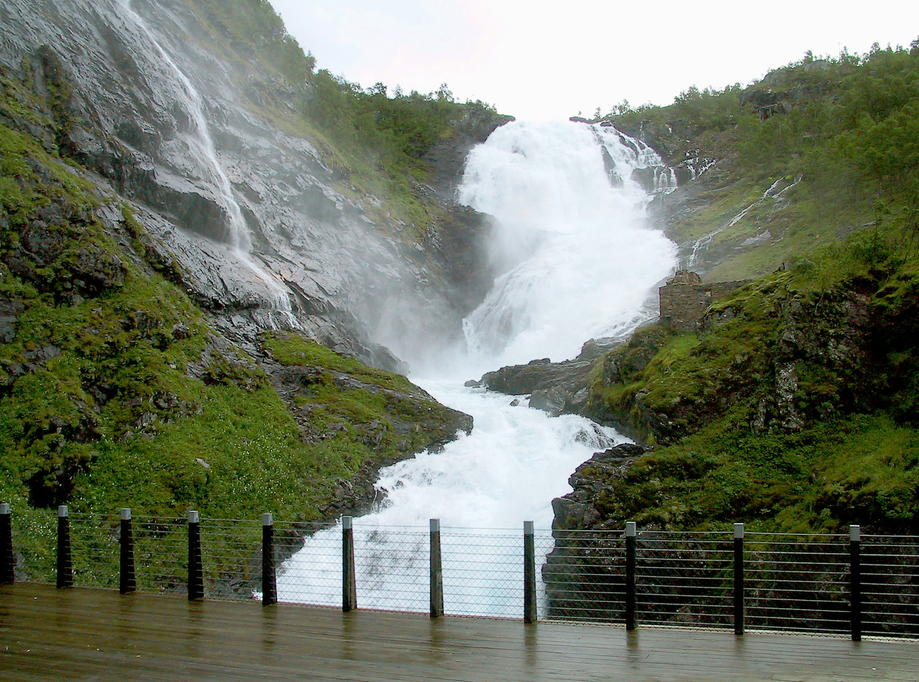 Malersiche Aussicht auf einen Wasserfall umgeben von Grün mit spritzendem Wasser