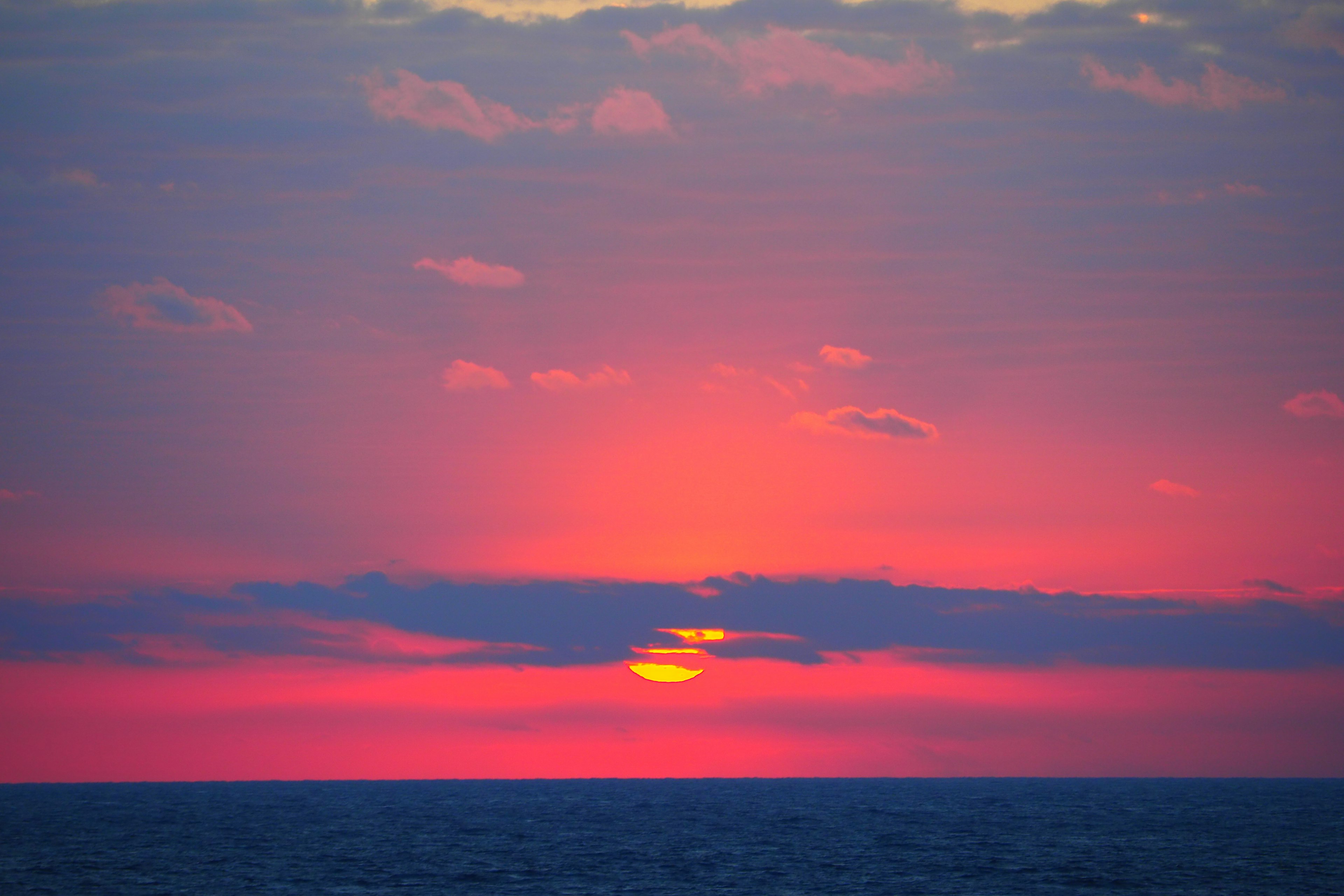 Paysage magnifique du coucher de soleil sur l'océan avec un ciel violet doux et un soleil orange