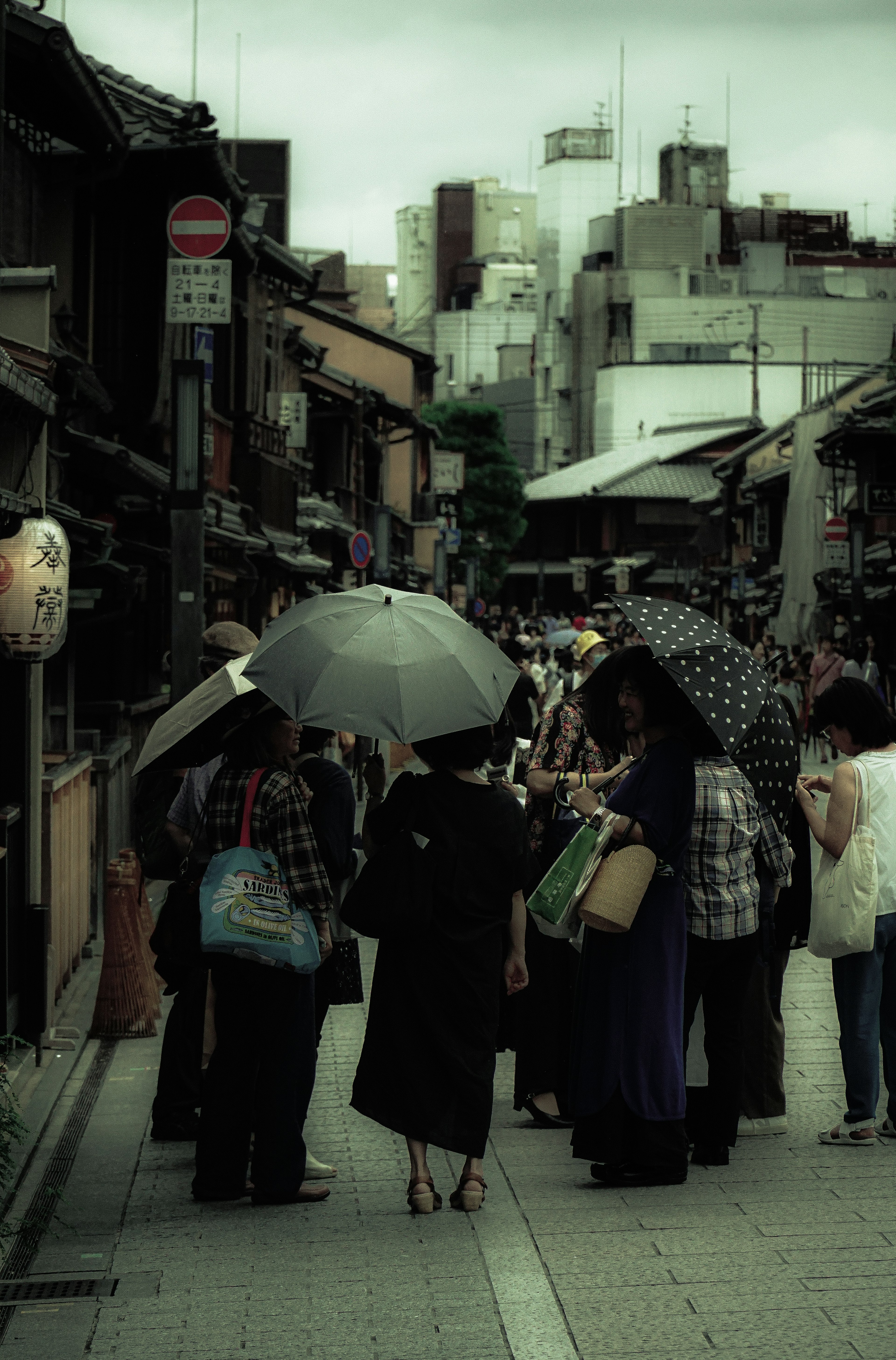 街道場景，有人撐傘，傳統建築與現代建築並存