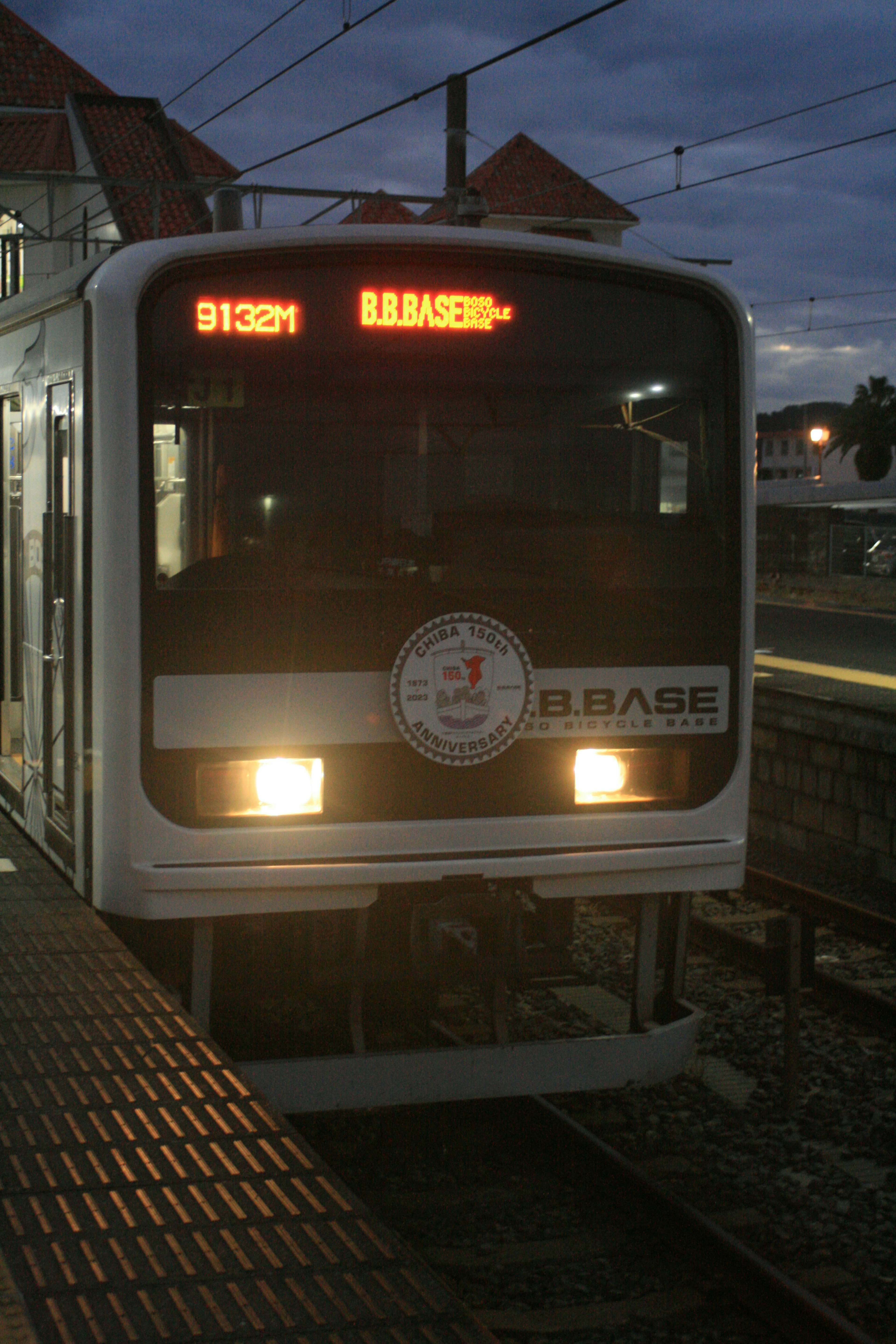 Train at a station during twilight LED display showing route information