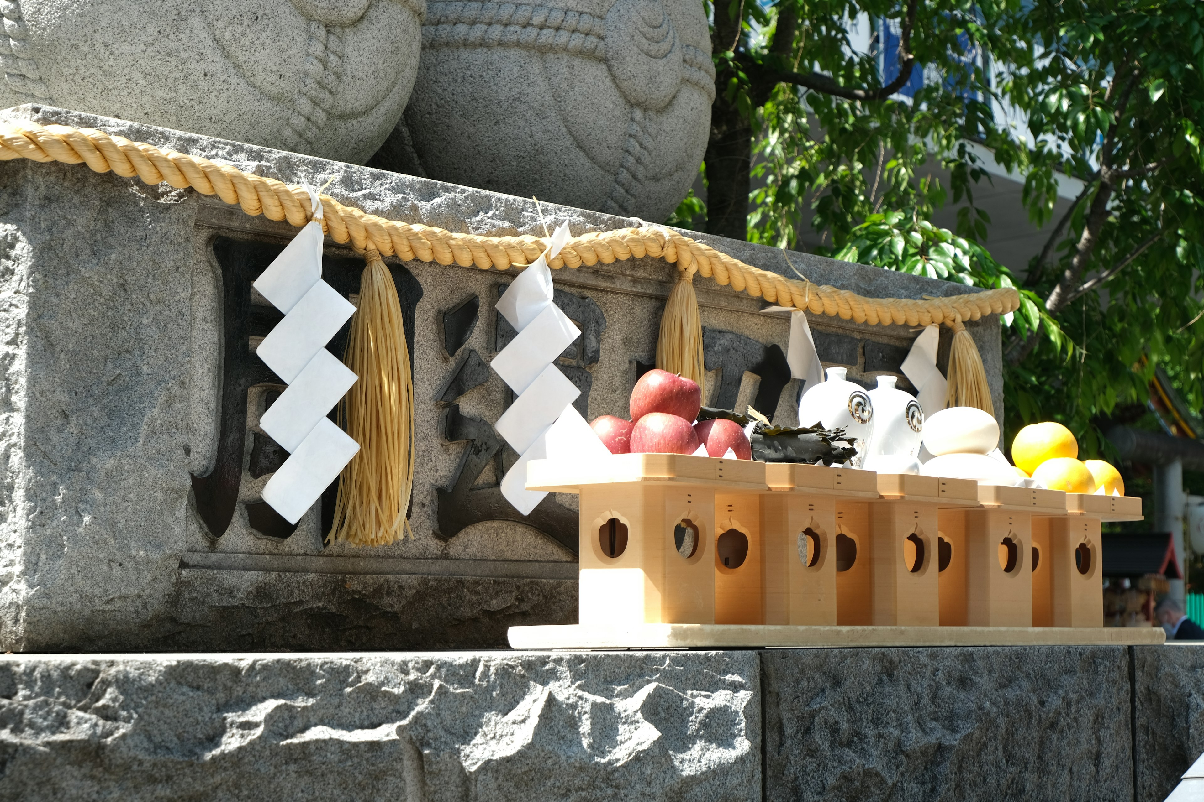 Offrandes de fruits disposées sur un autel de sanctuaire avec un décor en papier blanc